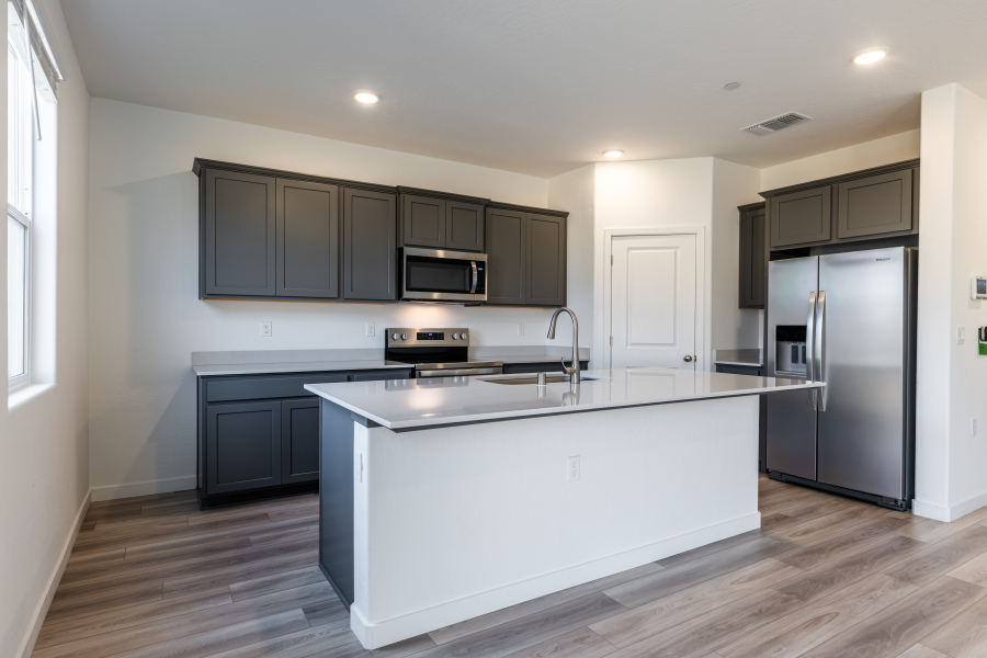 A kitchen with black cabinets.