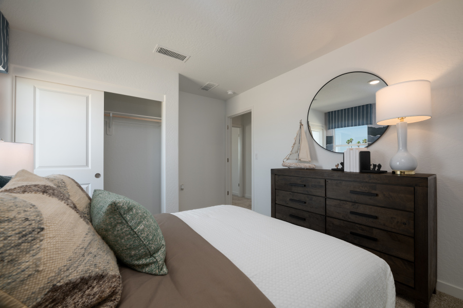 A bedroom with a bed and a mirror.