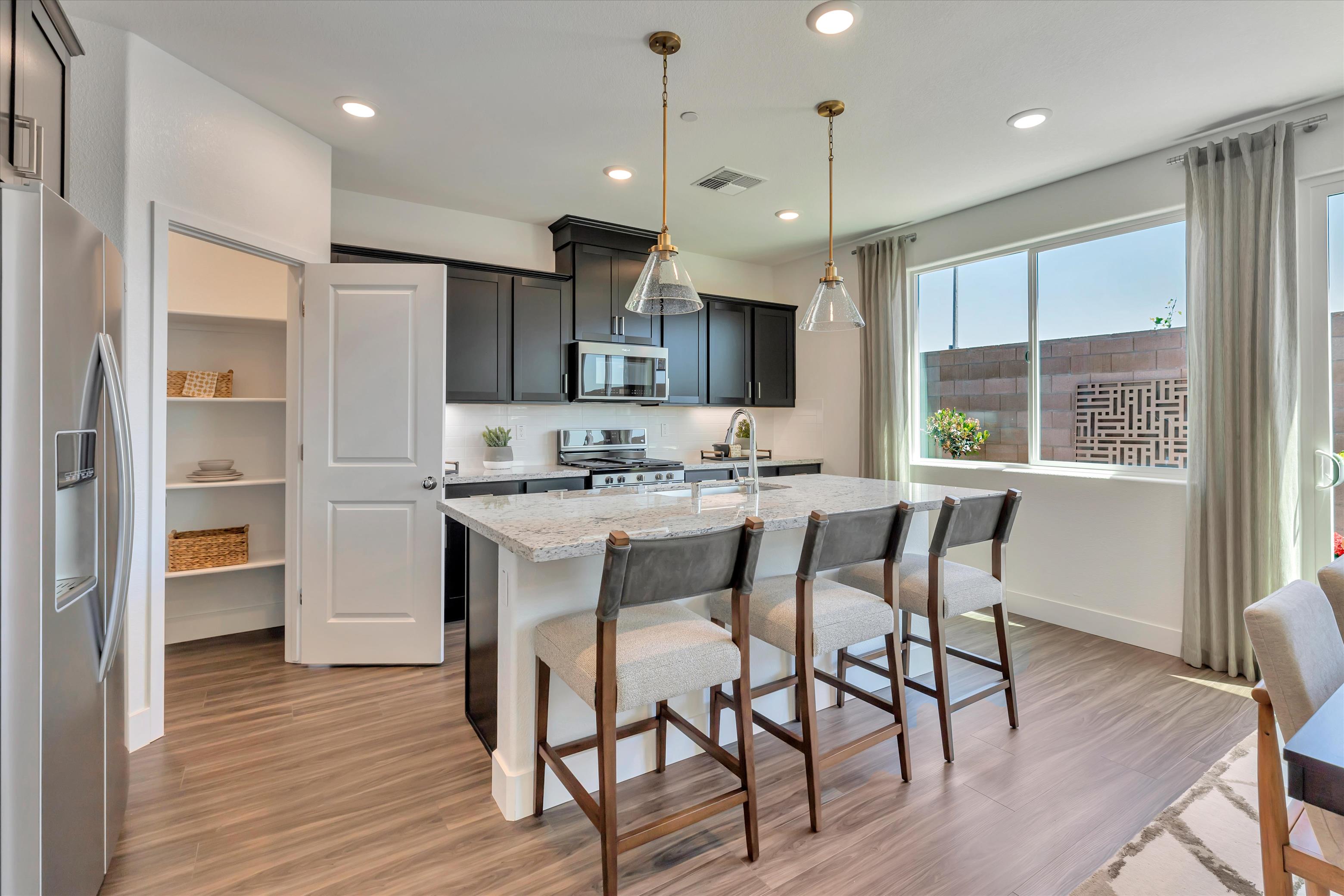 A kitchen with a dining table and chairs.