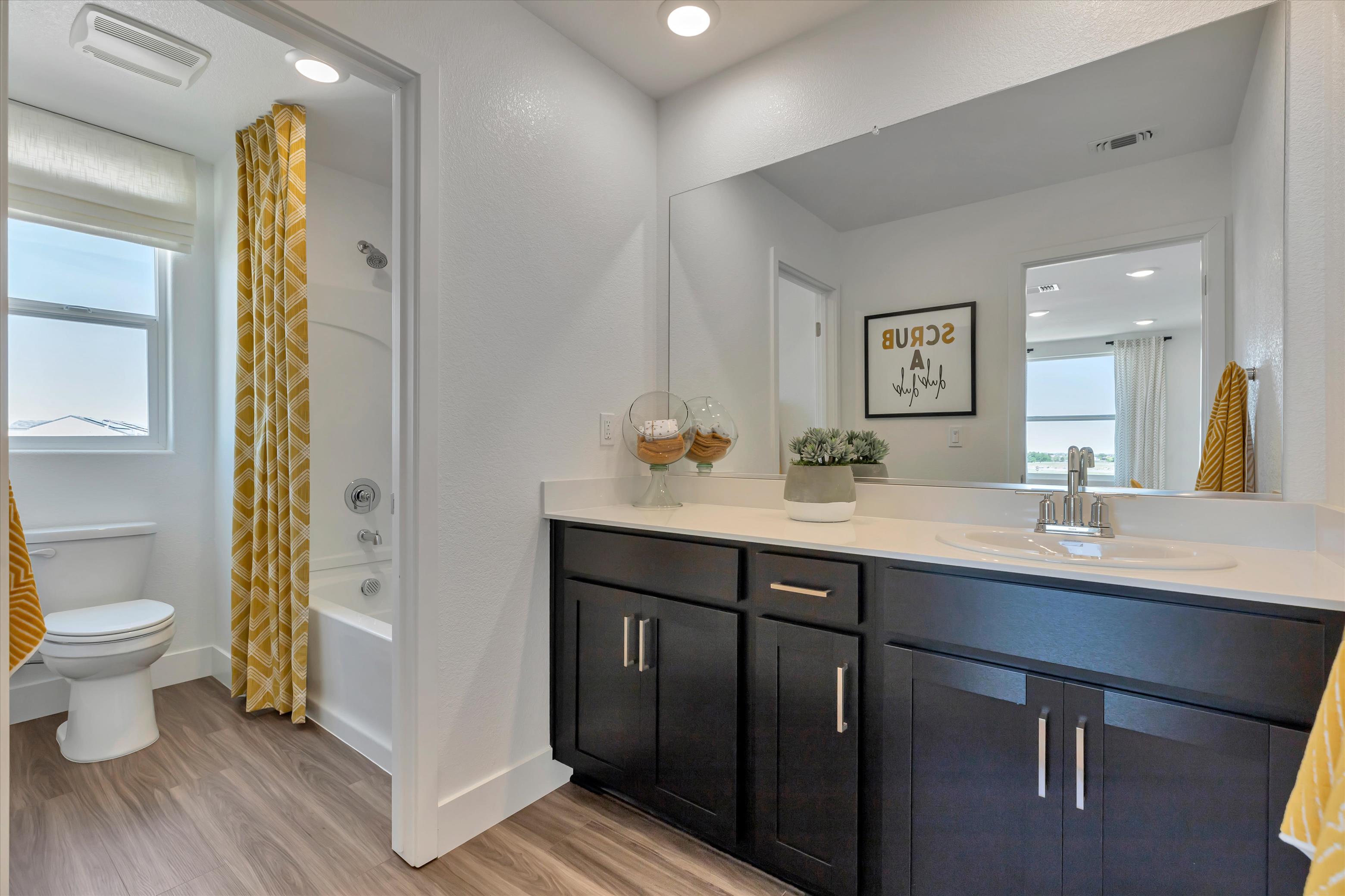 A bathroom with a tub sink and toilet.