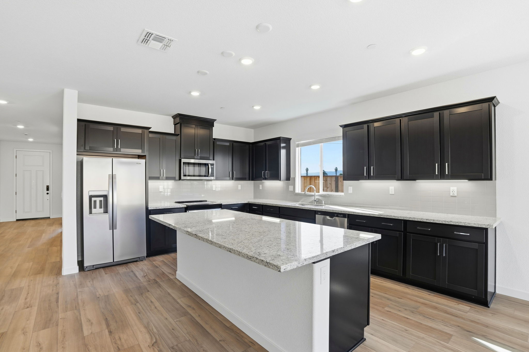 A kitchen with black cabinets.