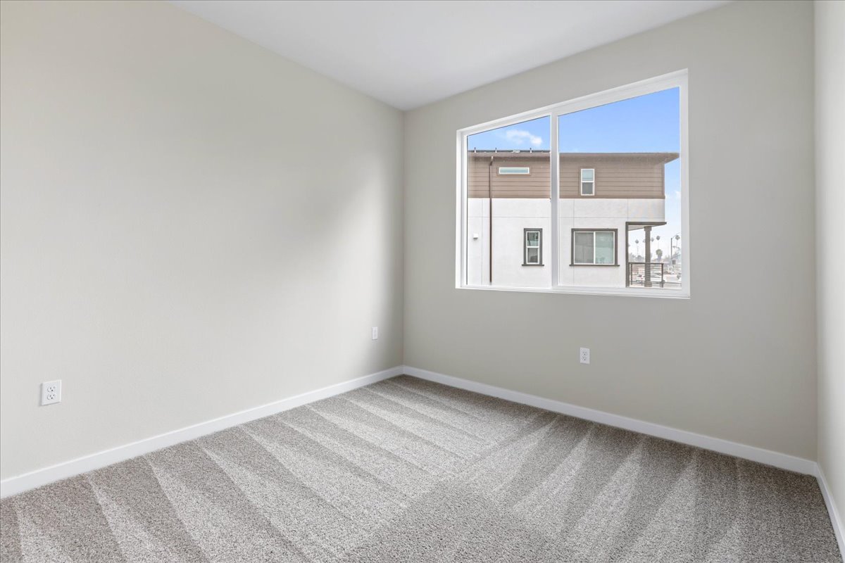 A room with a window and a rug.
