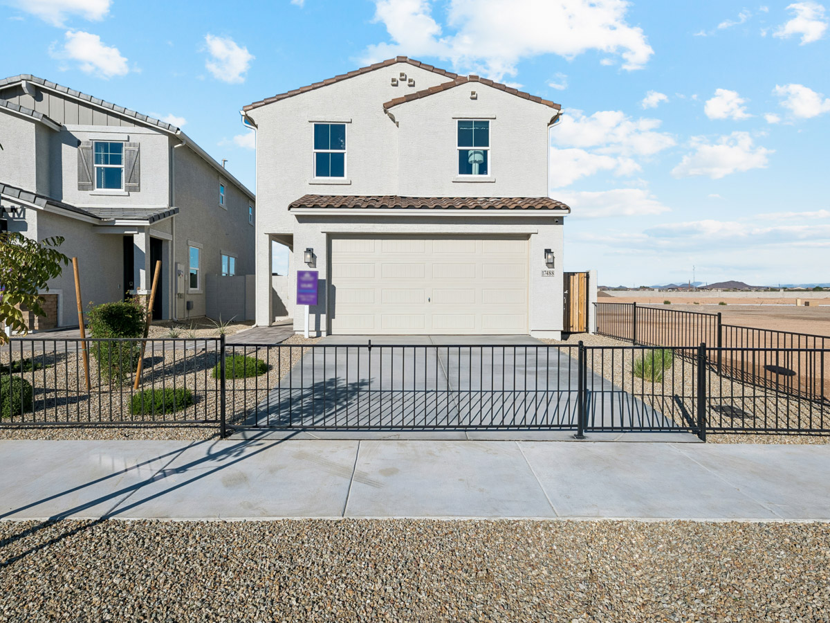 A white building with a black gate.