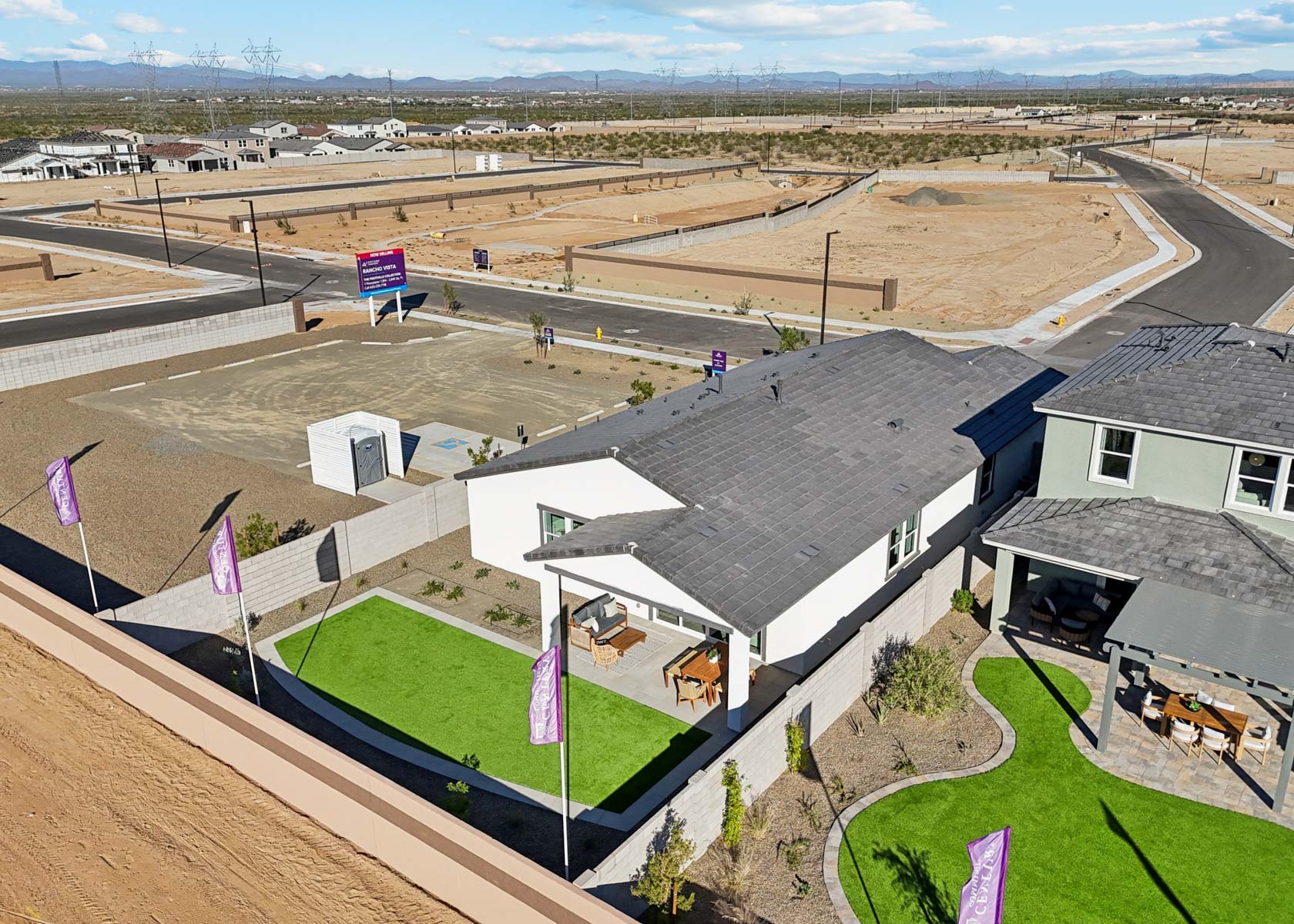 A building with a grass field and a dirt field.