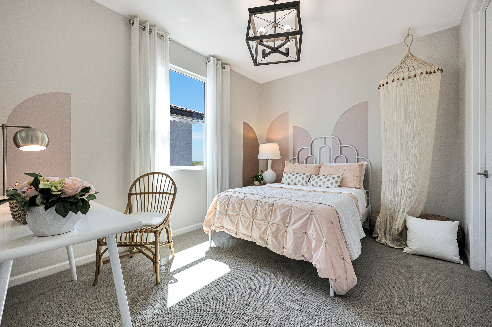 A bedroom with a bed and a table.