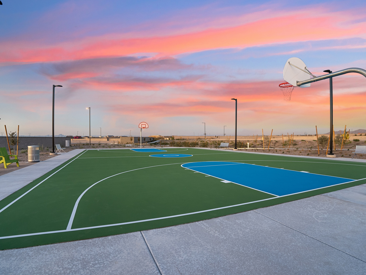 A sports field with a basketball hoop.