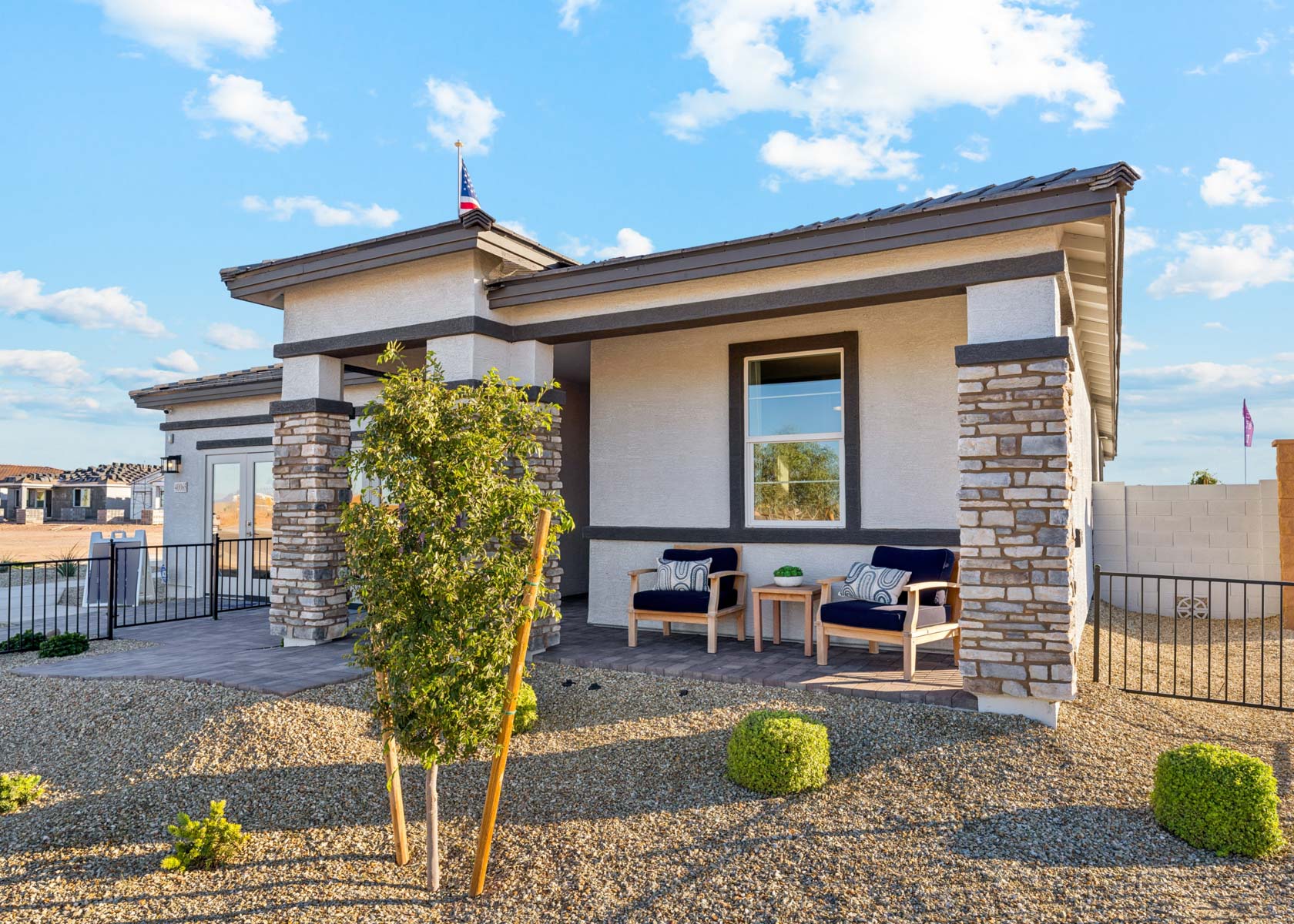 A house with a patio and a table and chairs in the front.