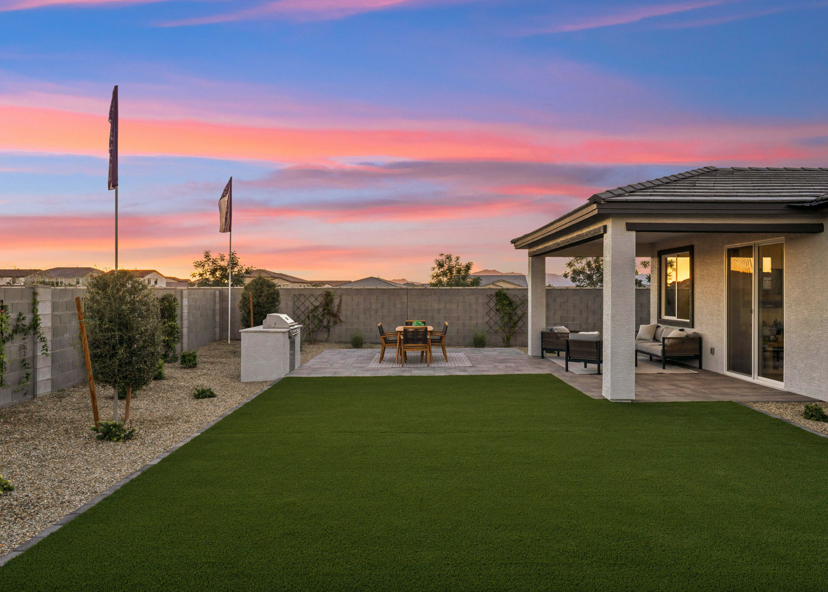 A building with a lawn and a table and chairs in the front.