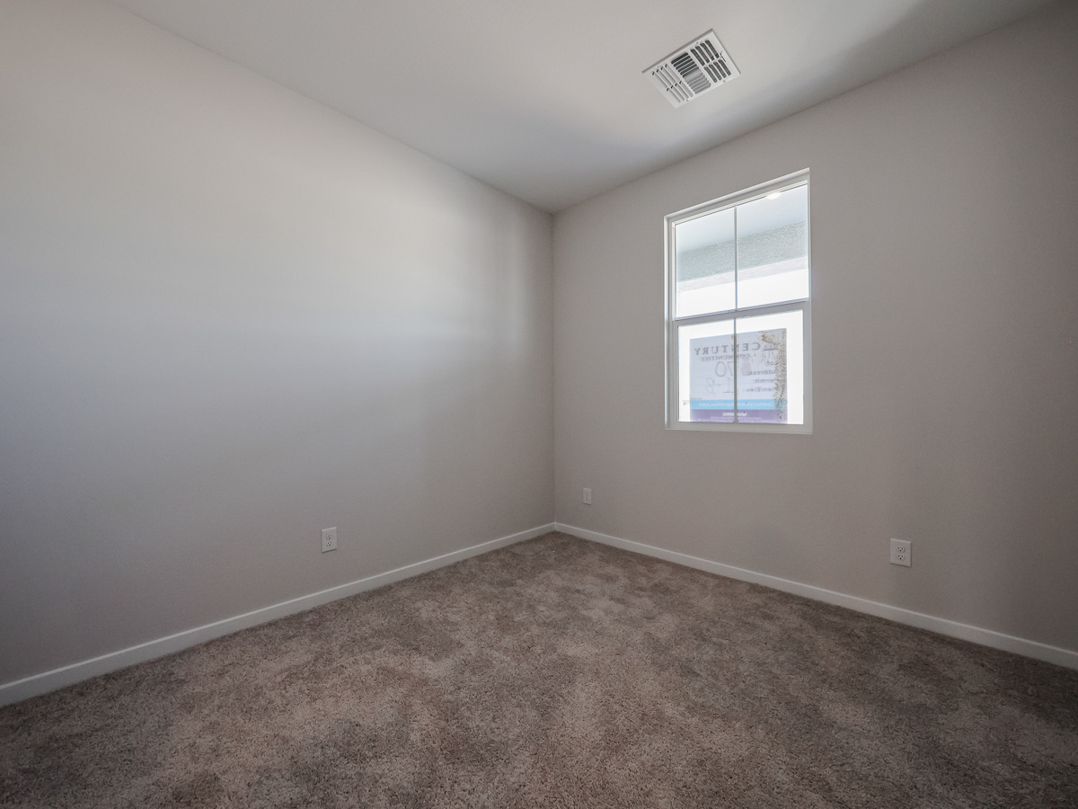 A room with a window and carpet.