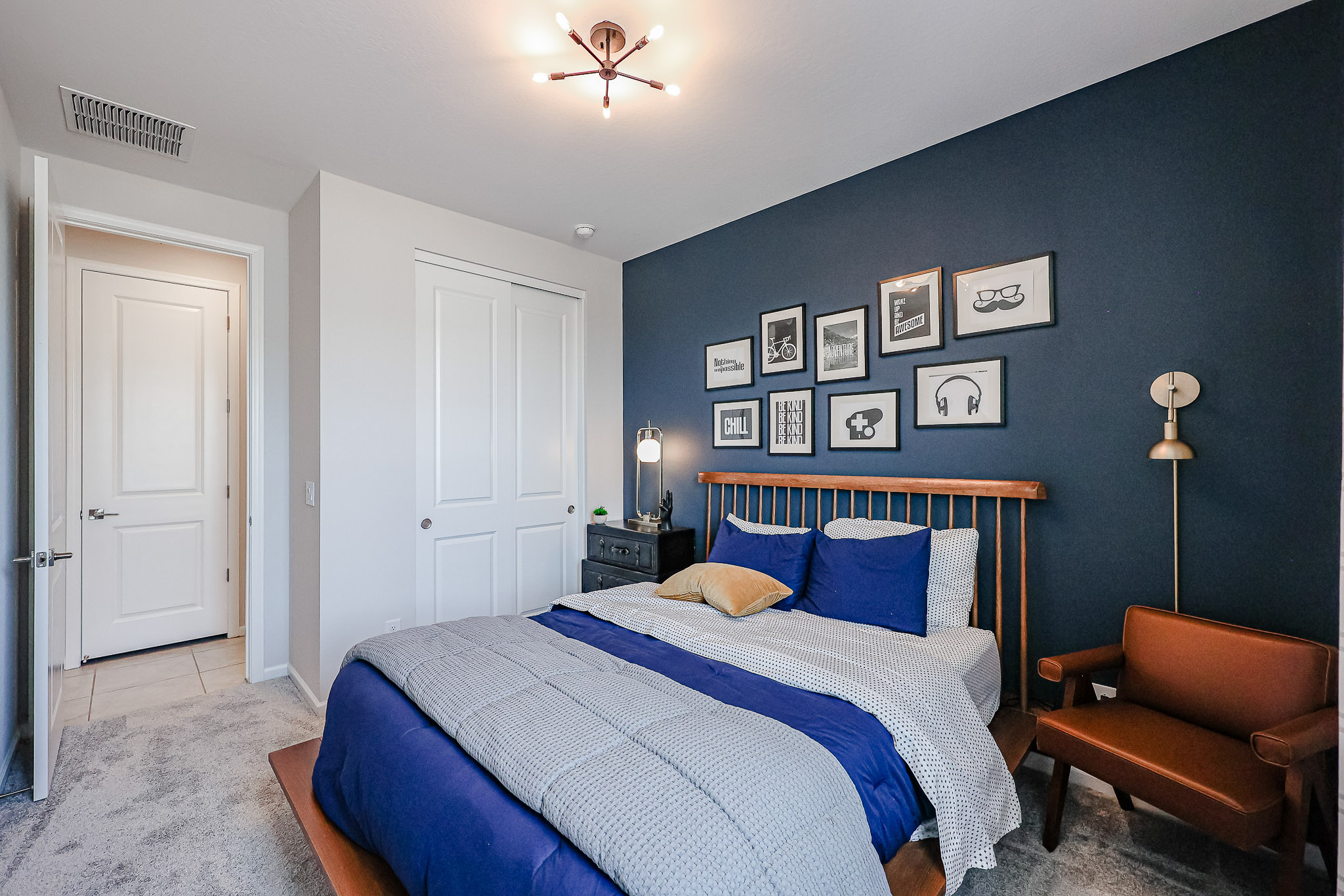 A bedroom with a bed and a chair.