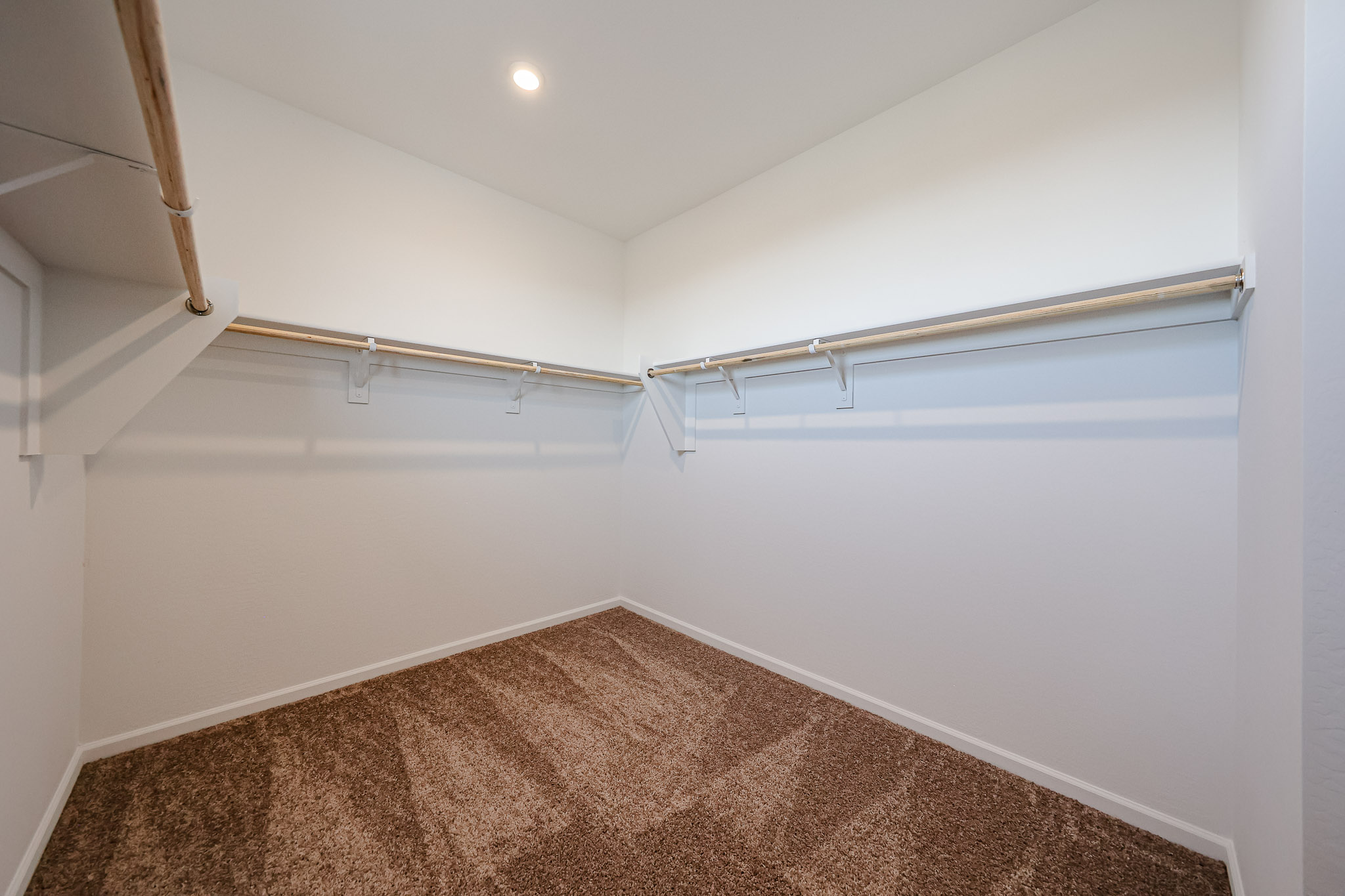 A room with a carpet and a white wall.