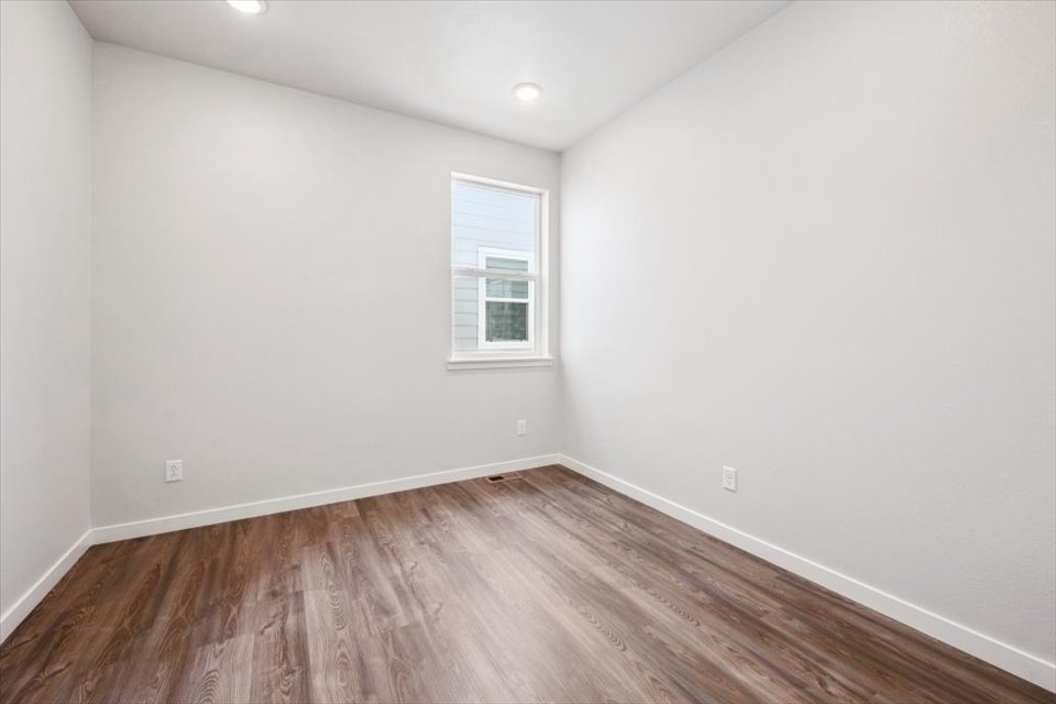 A room with a wood floor and a window.