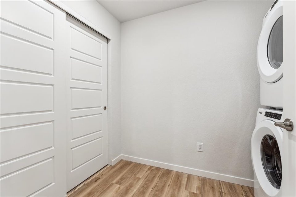 A white room with a washing machine and a dryer.