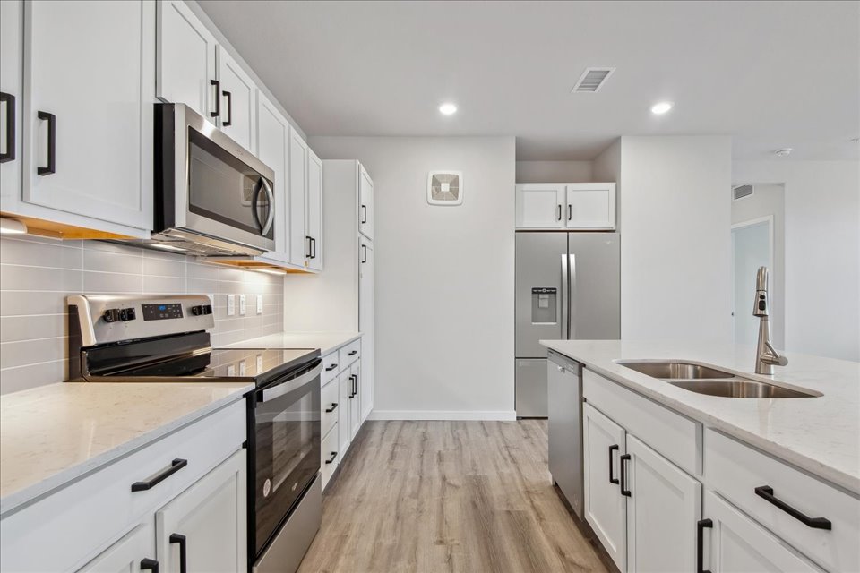 A kitchen with white cabinets.