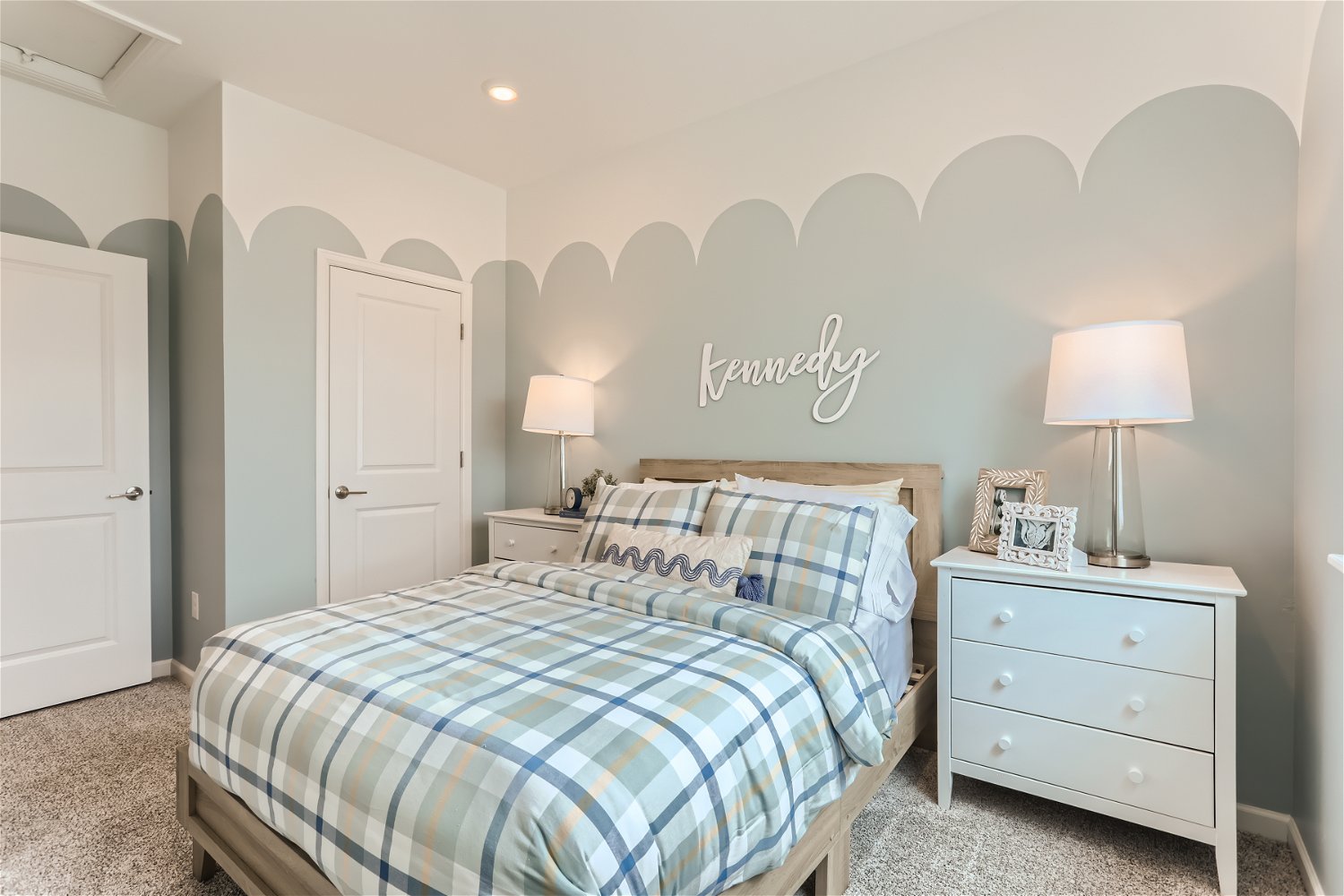 A bedroom with a bed and lamps.