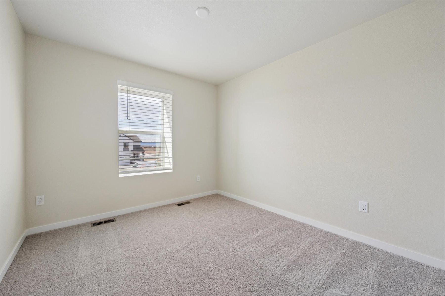 A room with a window and carpet.