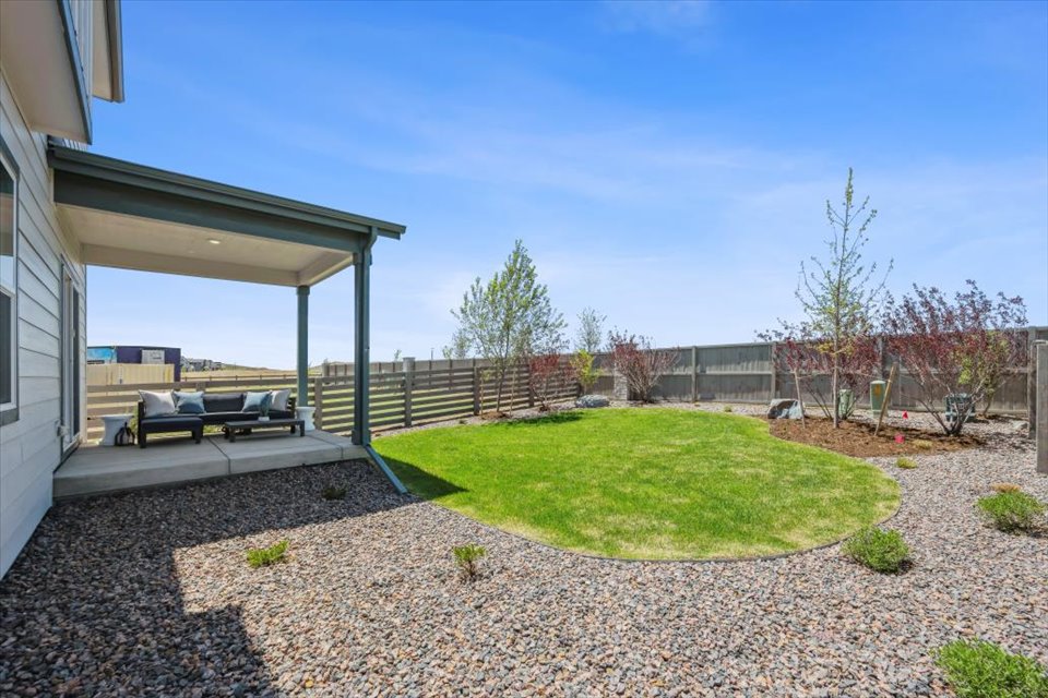 A backyard with a covered patio.