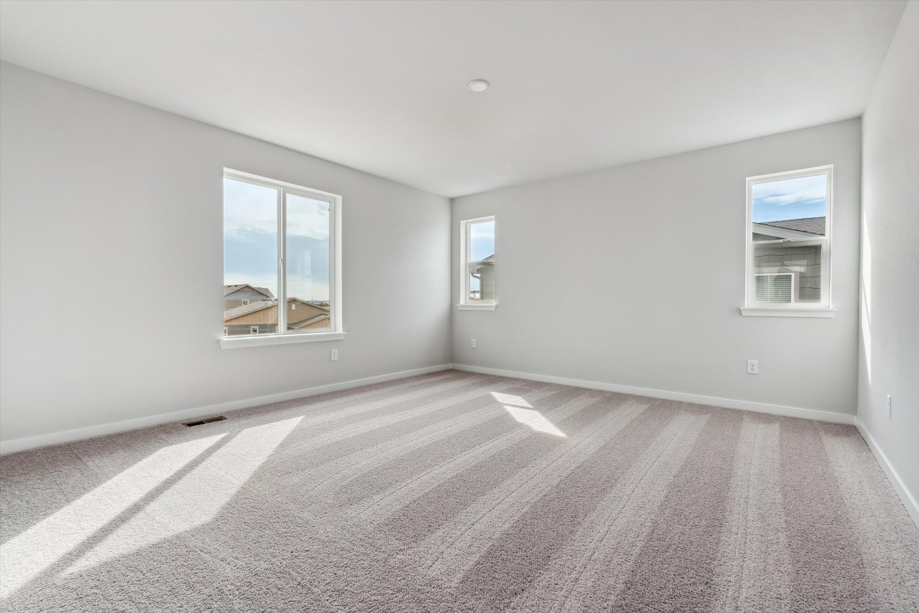 A room with a carpet and windows.