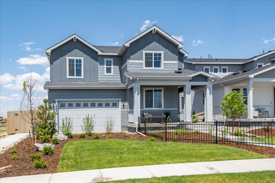 A house with a fence and lawn.