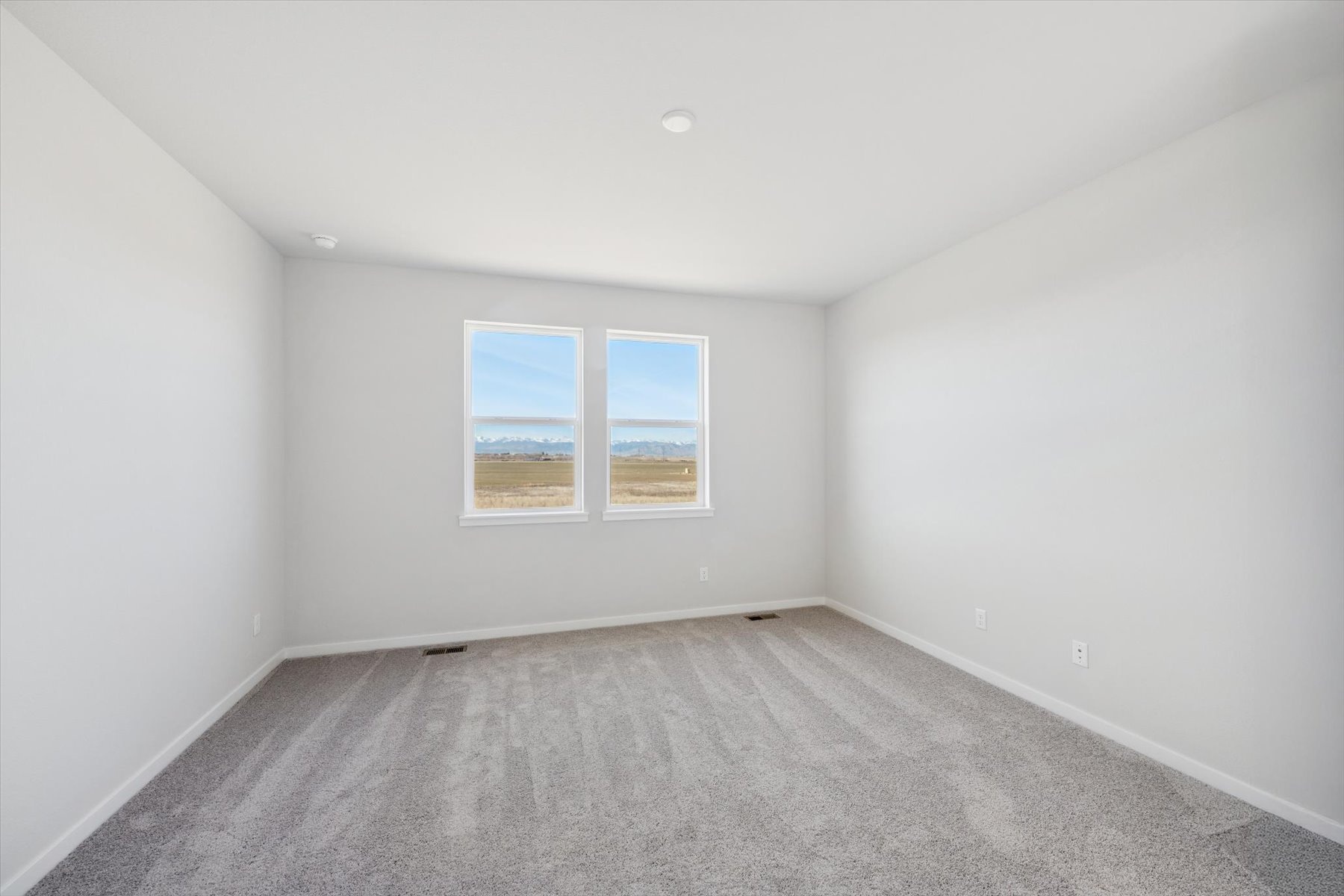 A room with a window and a carpet.