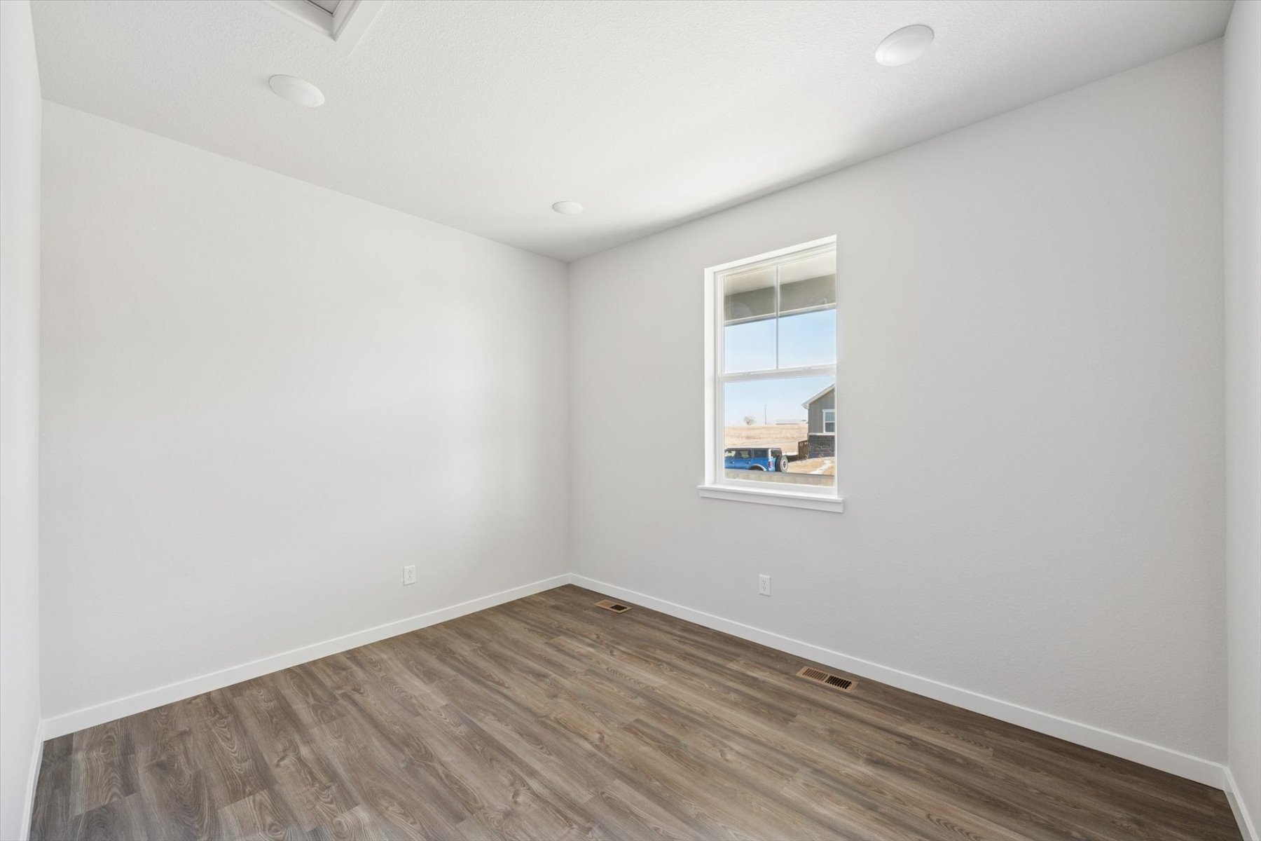 A room with a wood floor and a window.