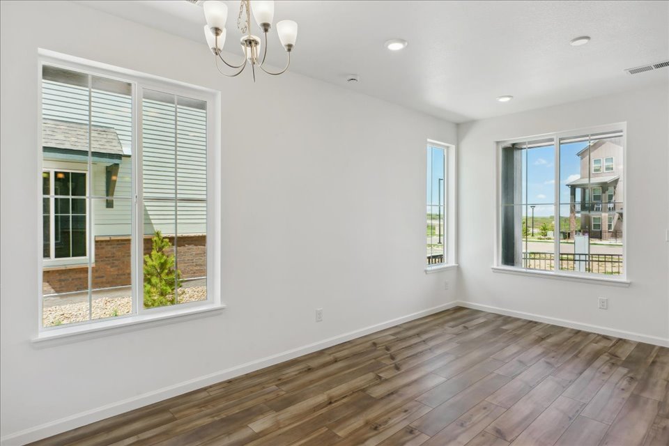 A room with windows and a wood floor.