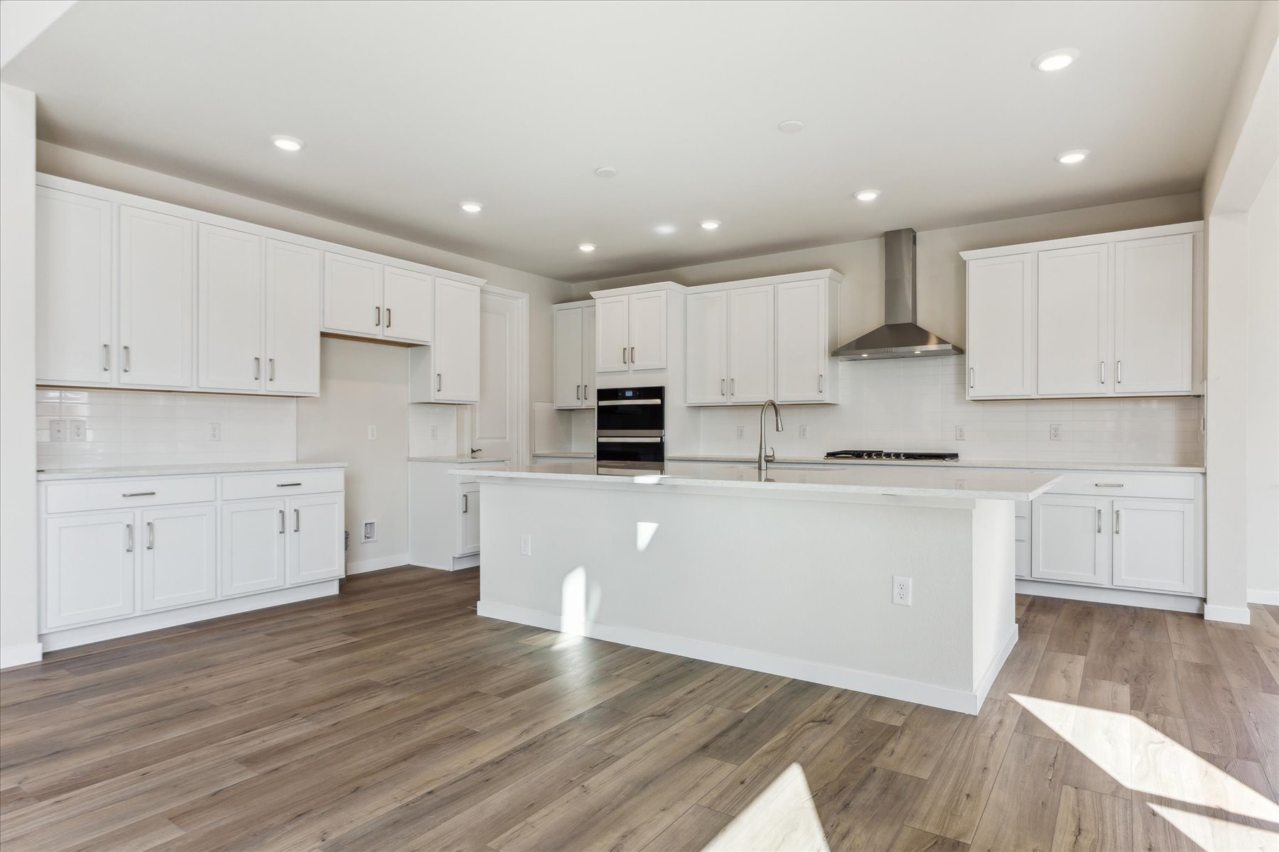 A kitchen with white cabinets.