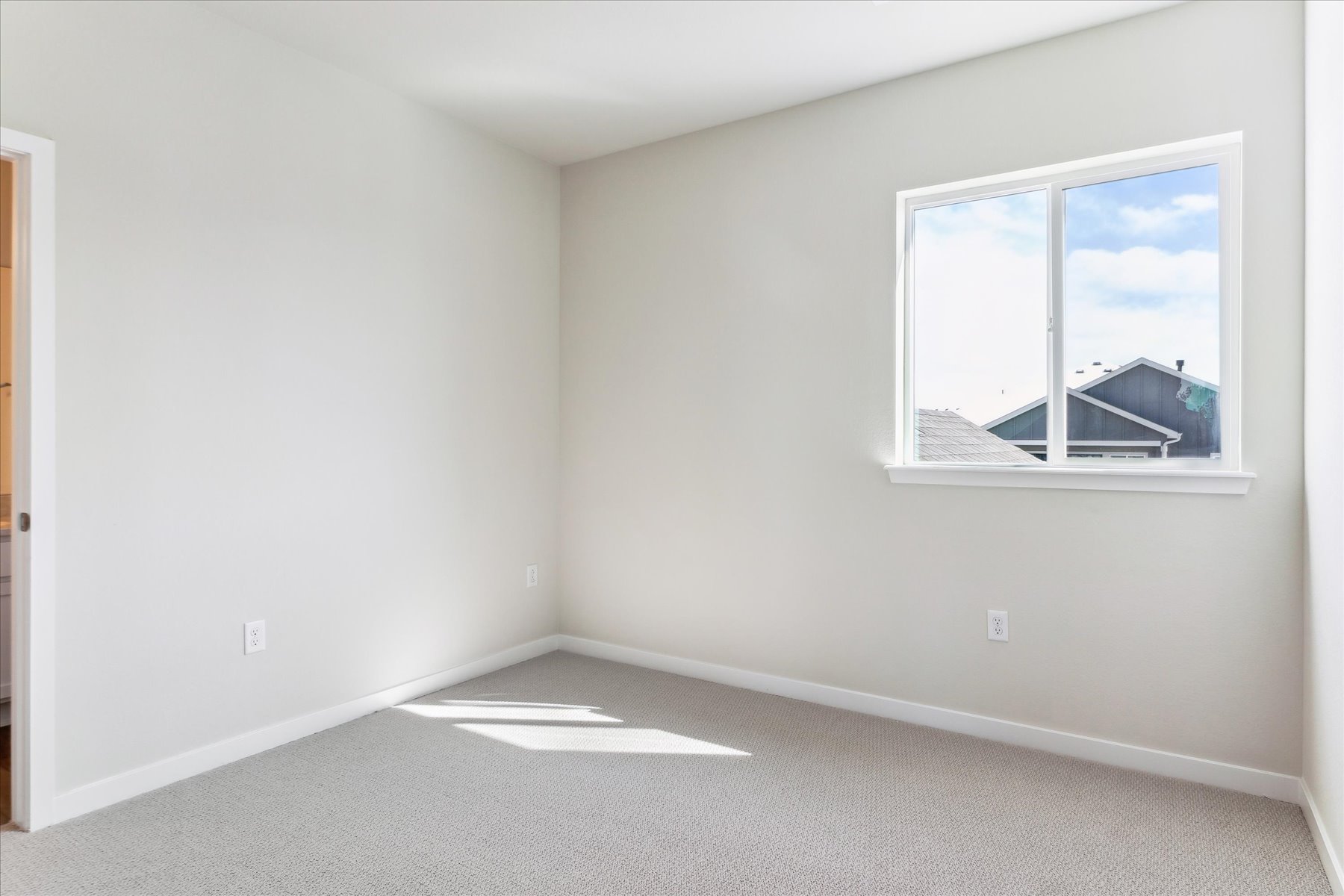 A room with a window and a rug in it.