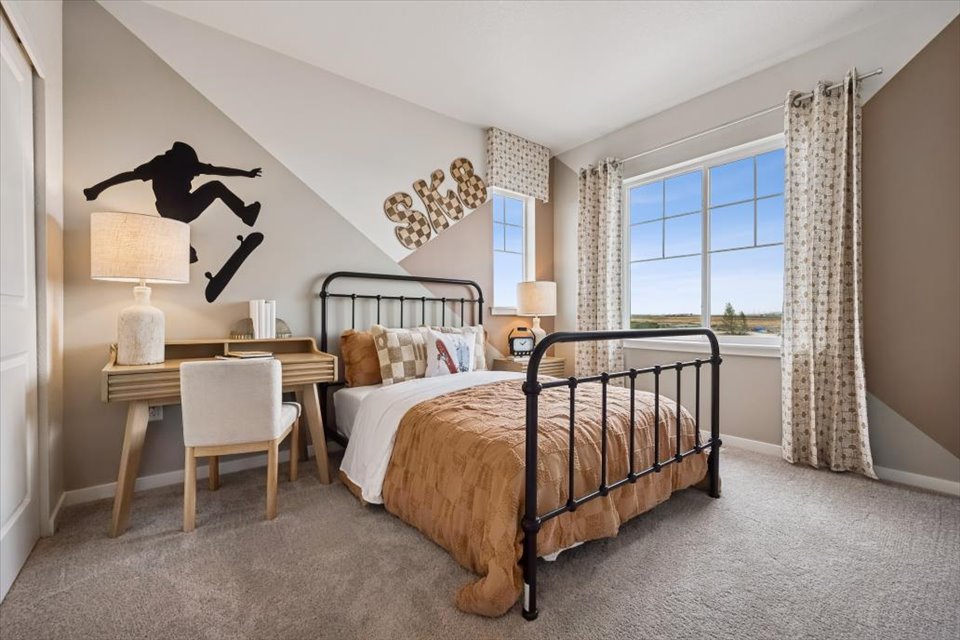 A bedroom with a bed and a desk.