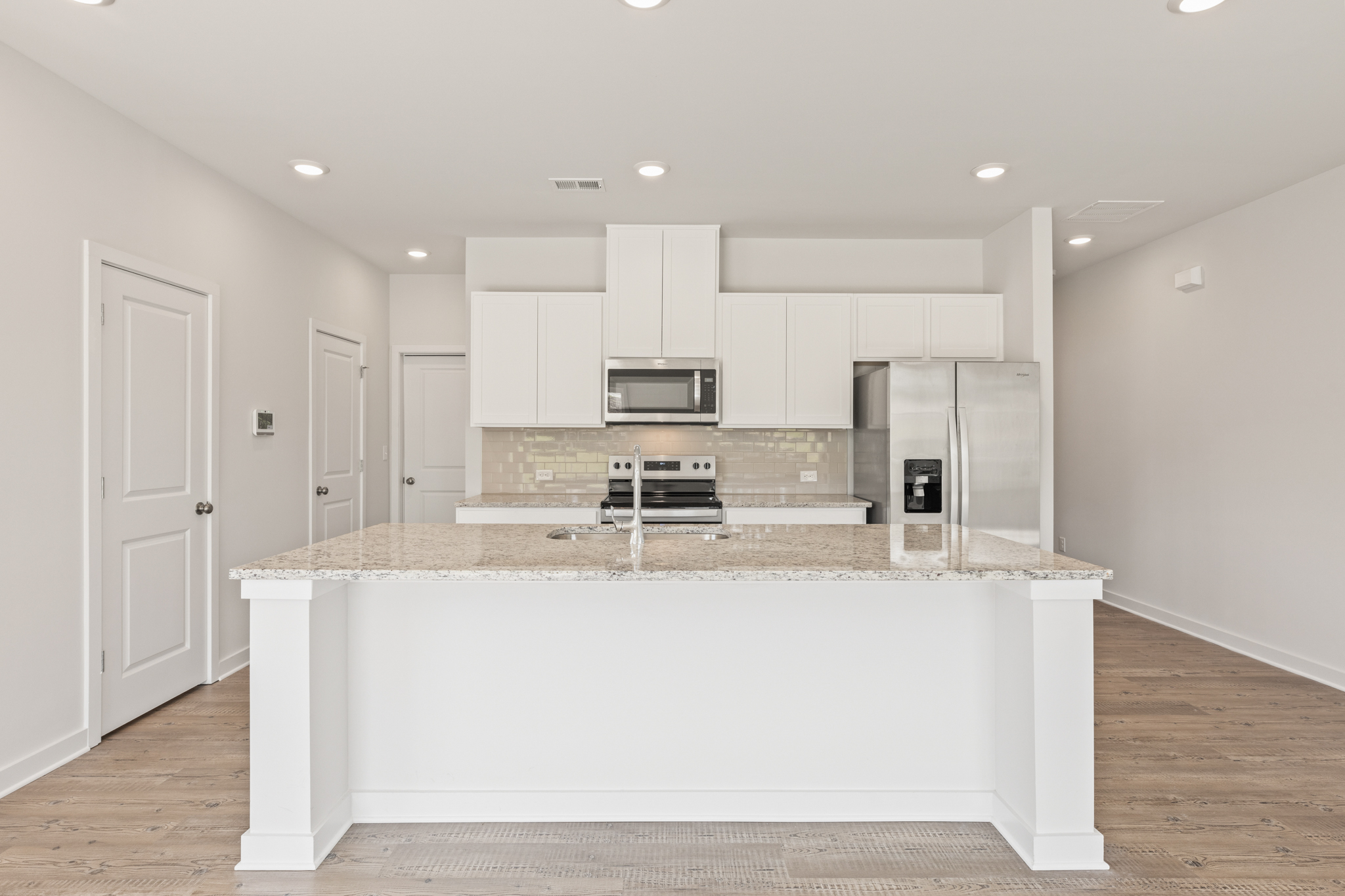 A kitchen with white cabinets.