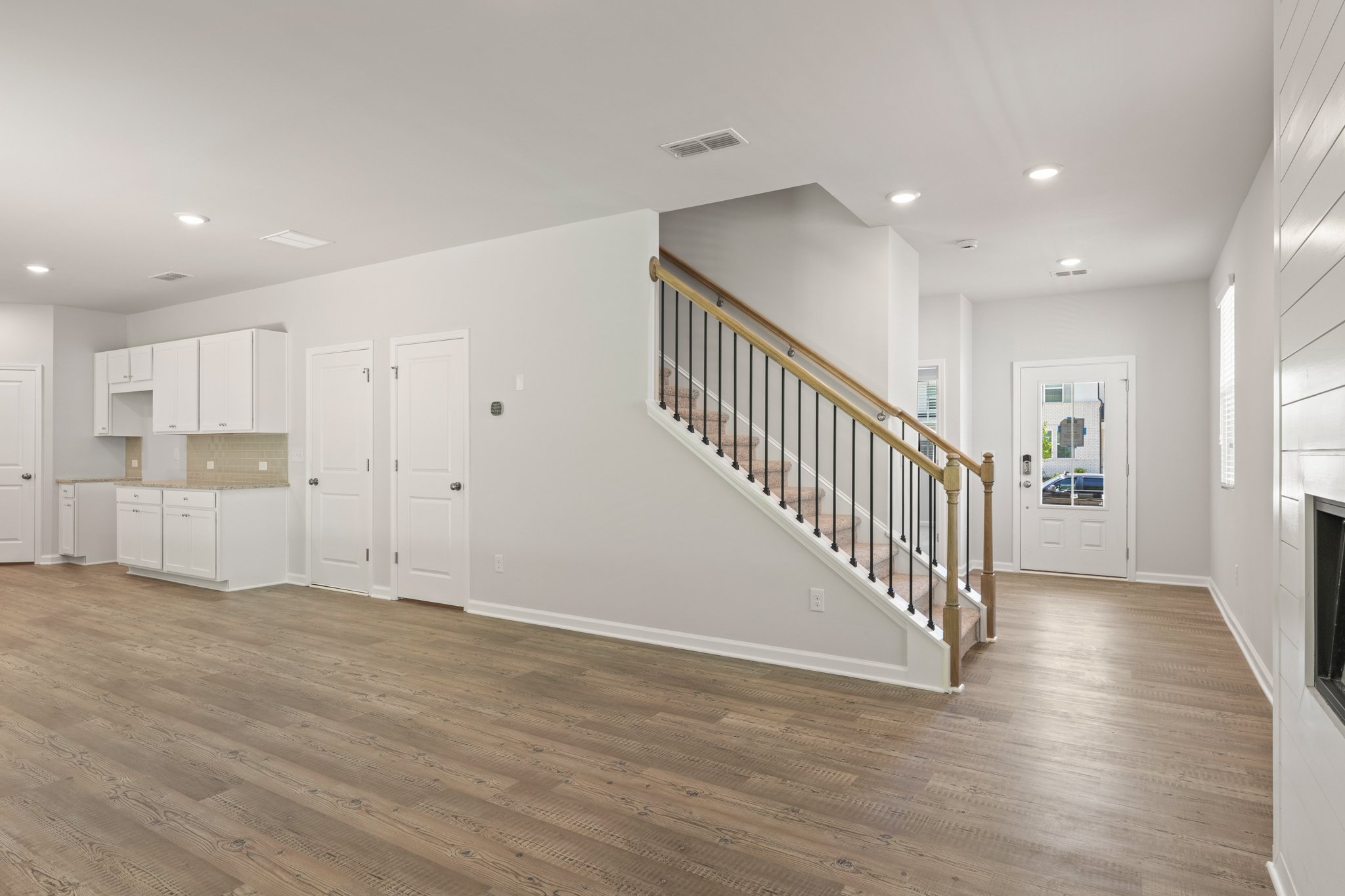 A long hallway with white doors.
