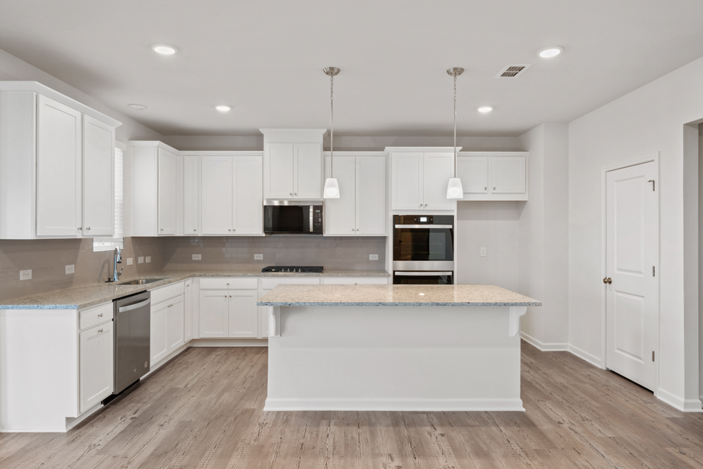 A kitchen with white cabinets.