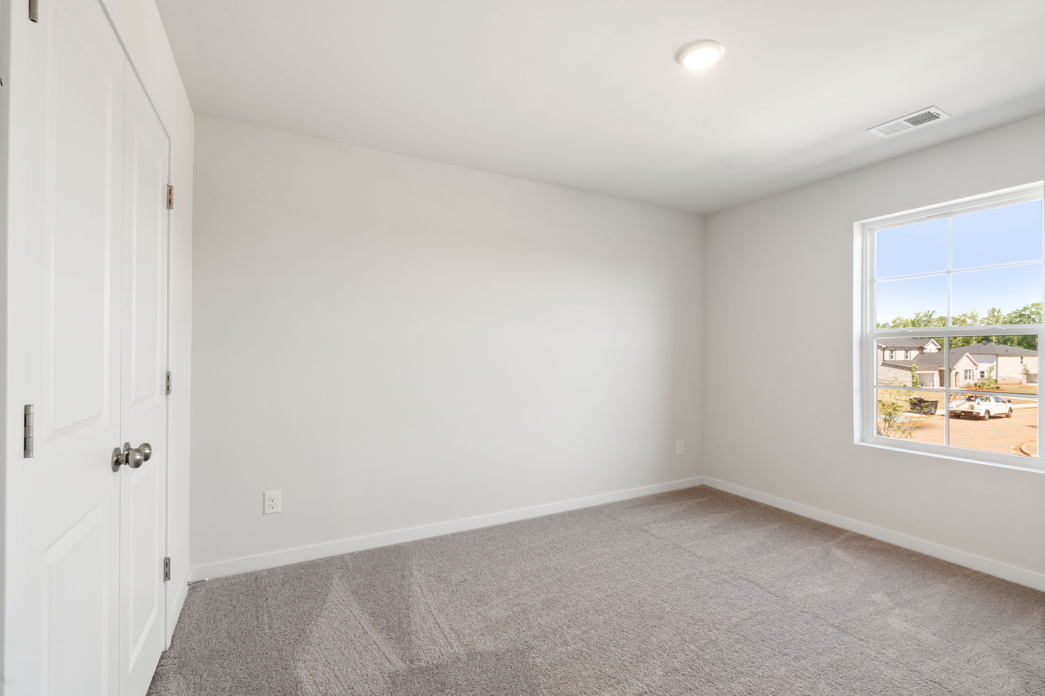 A room with a carpet and a window.