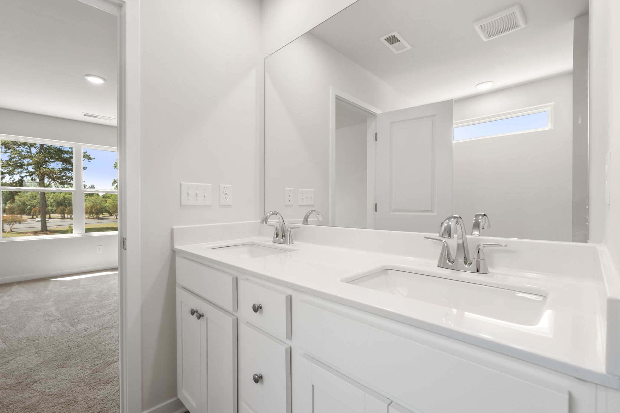 A bathroom with a large mirror.