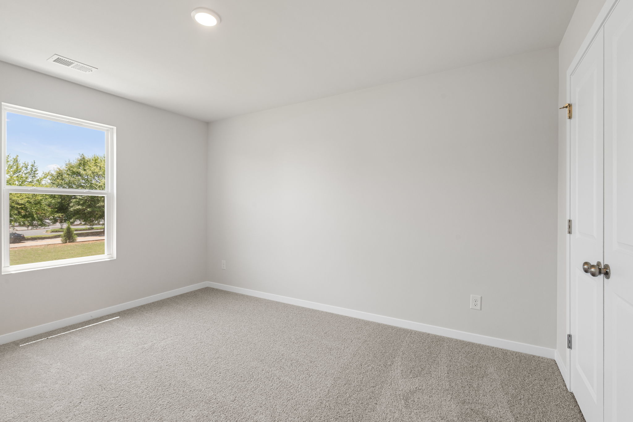 A room with a window and a carpet.