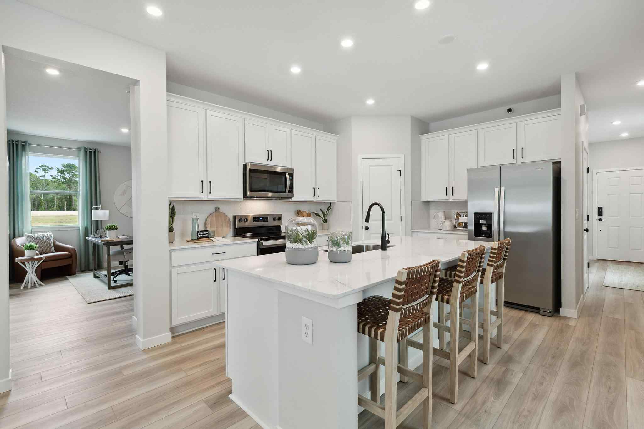 A kitchen with white cabinets.