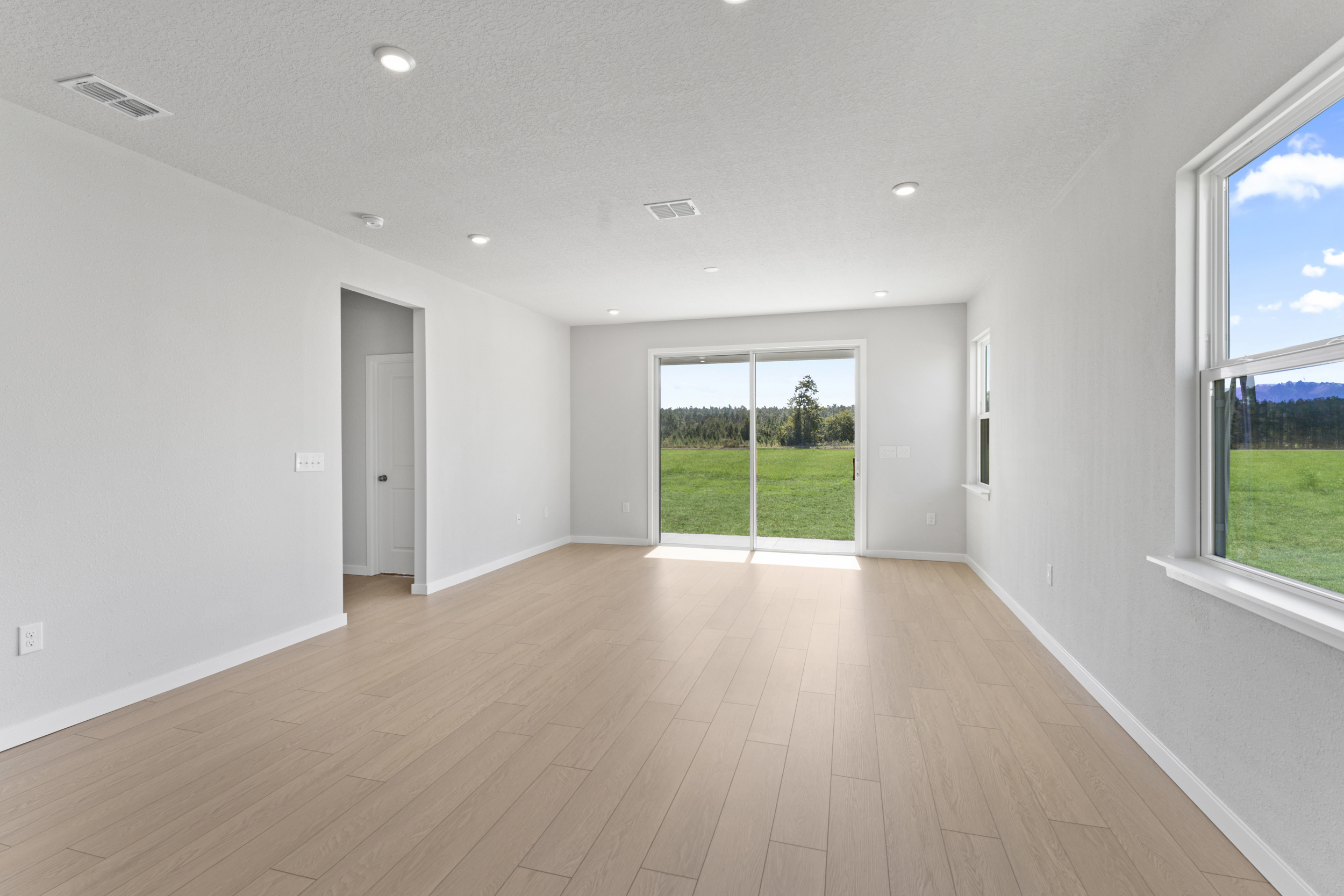 A room with a wood floor and windows.