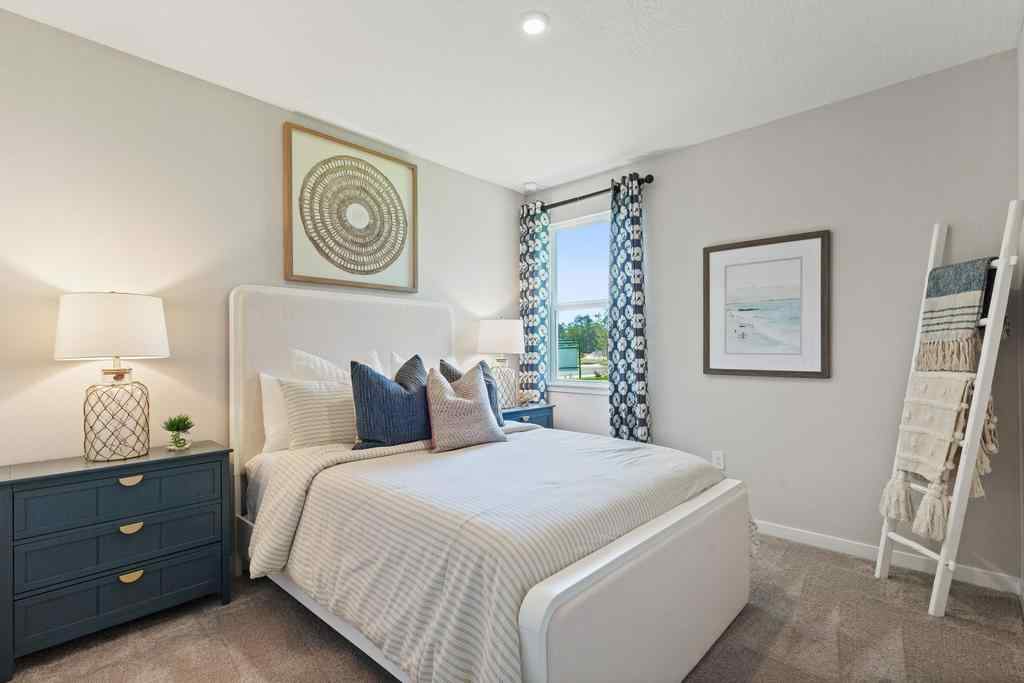 A bedroom with a bed and a lamp.