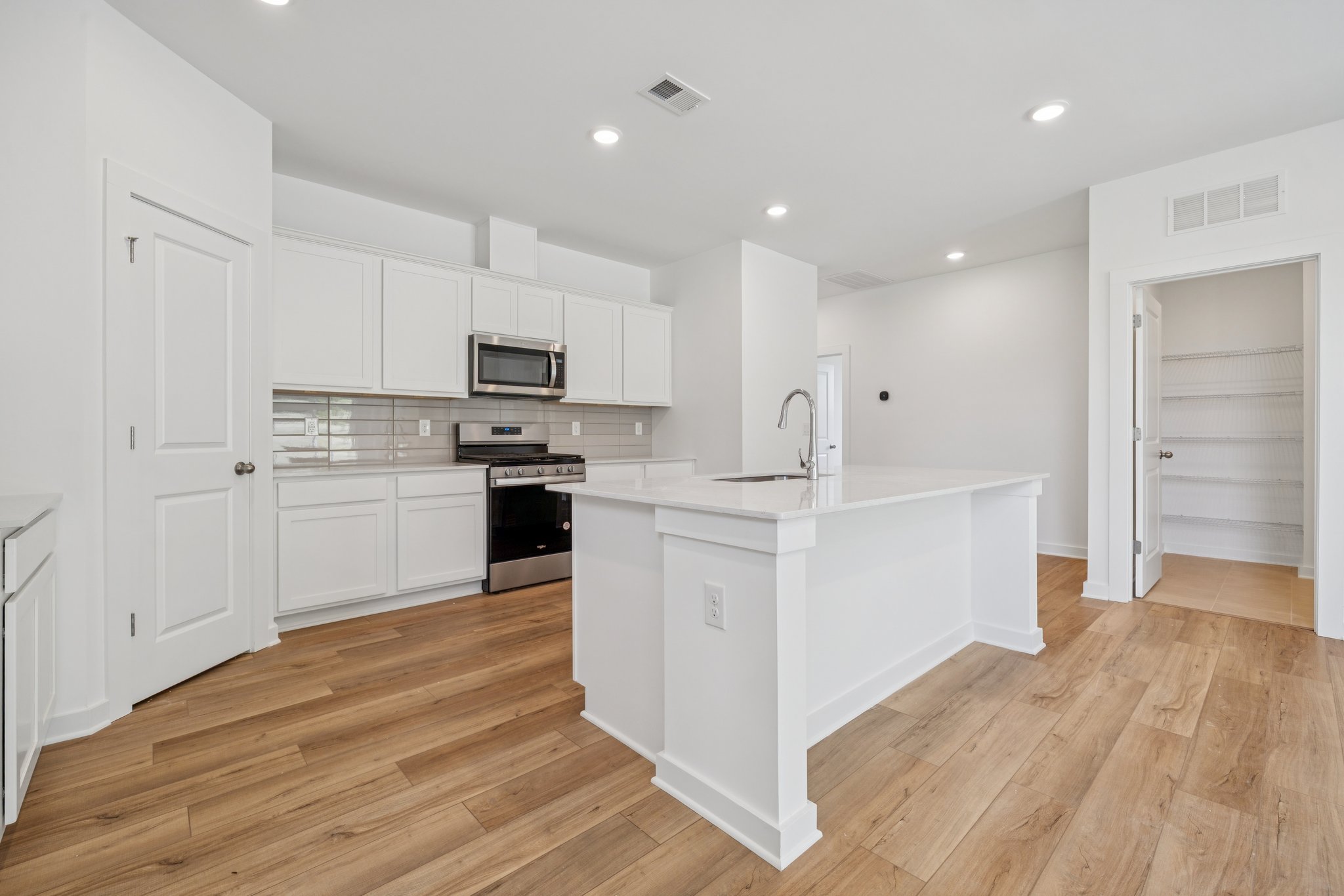A kitchen with white cabinets.