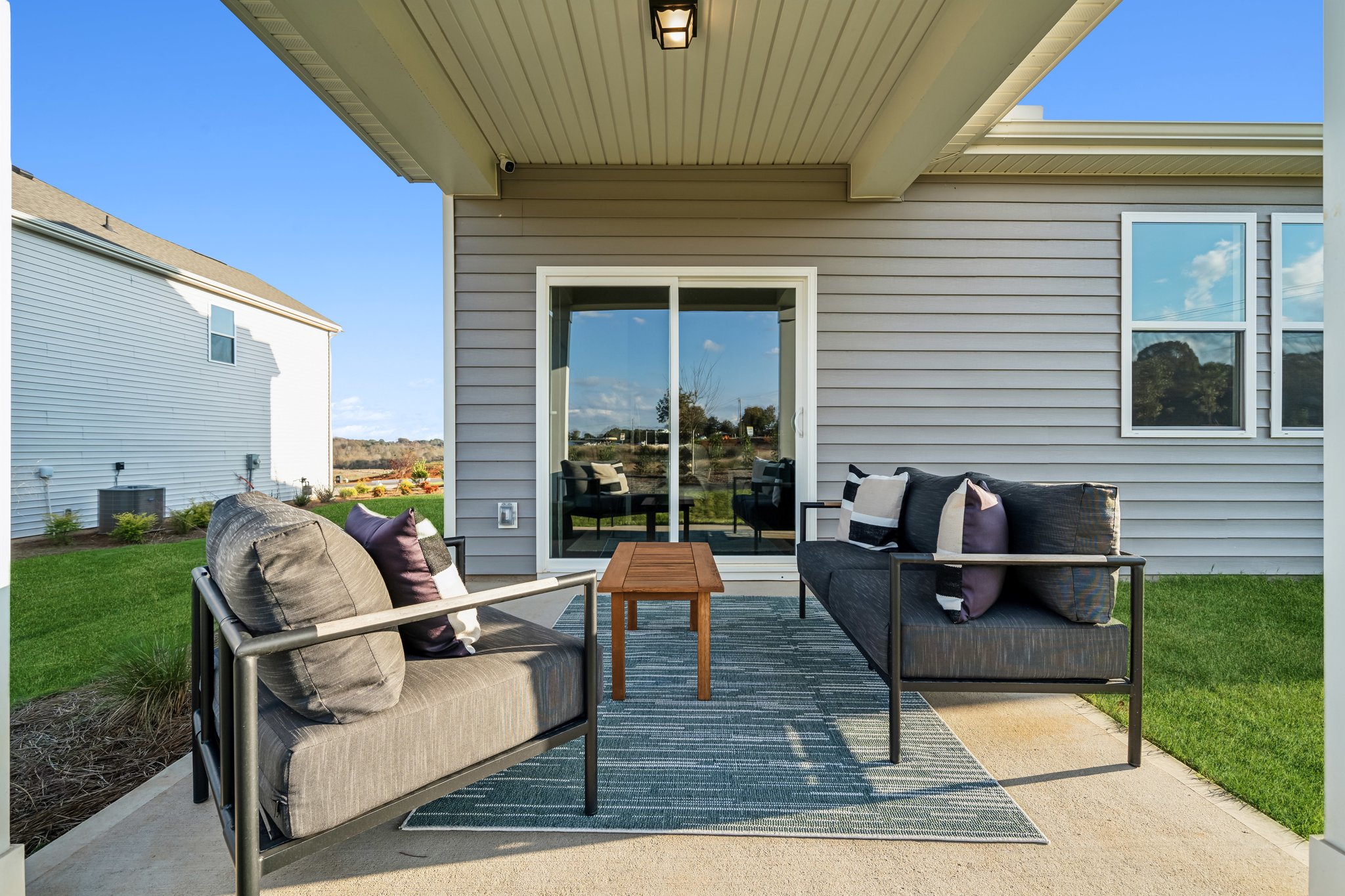 A person lying on a couch outside a house.