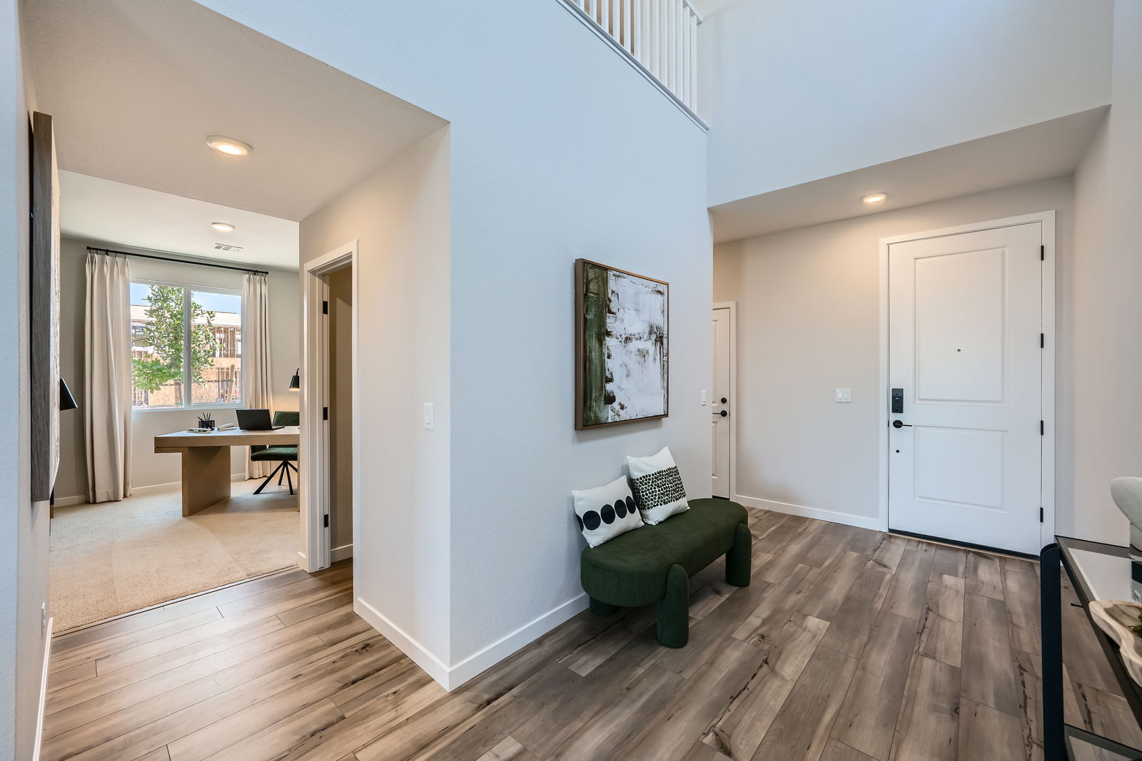 A room with a wood floor and a green chair.