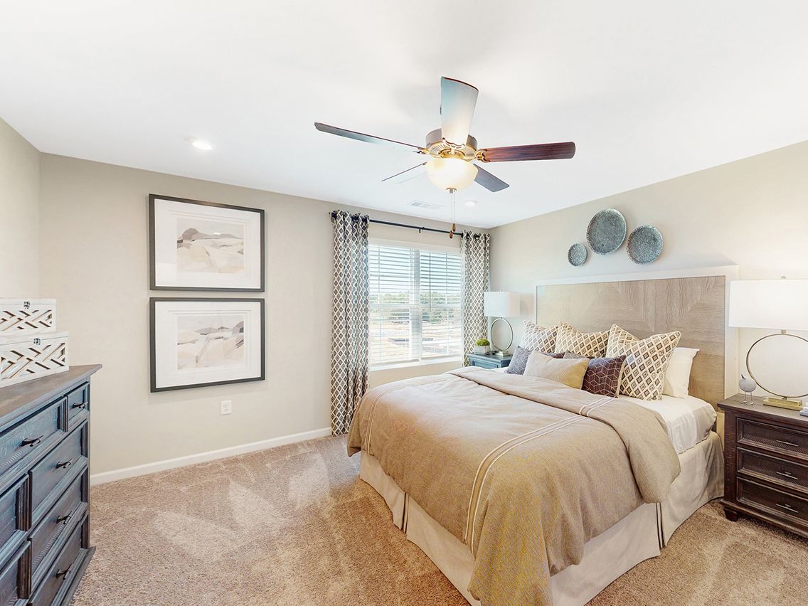 A bedroom with a bed and a fan.