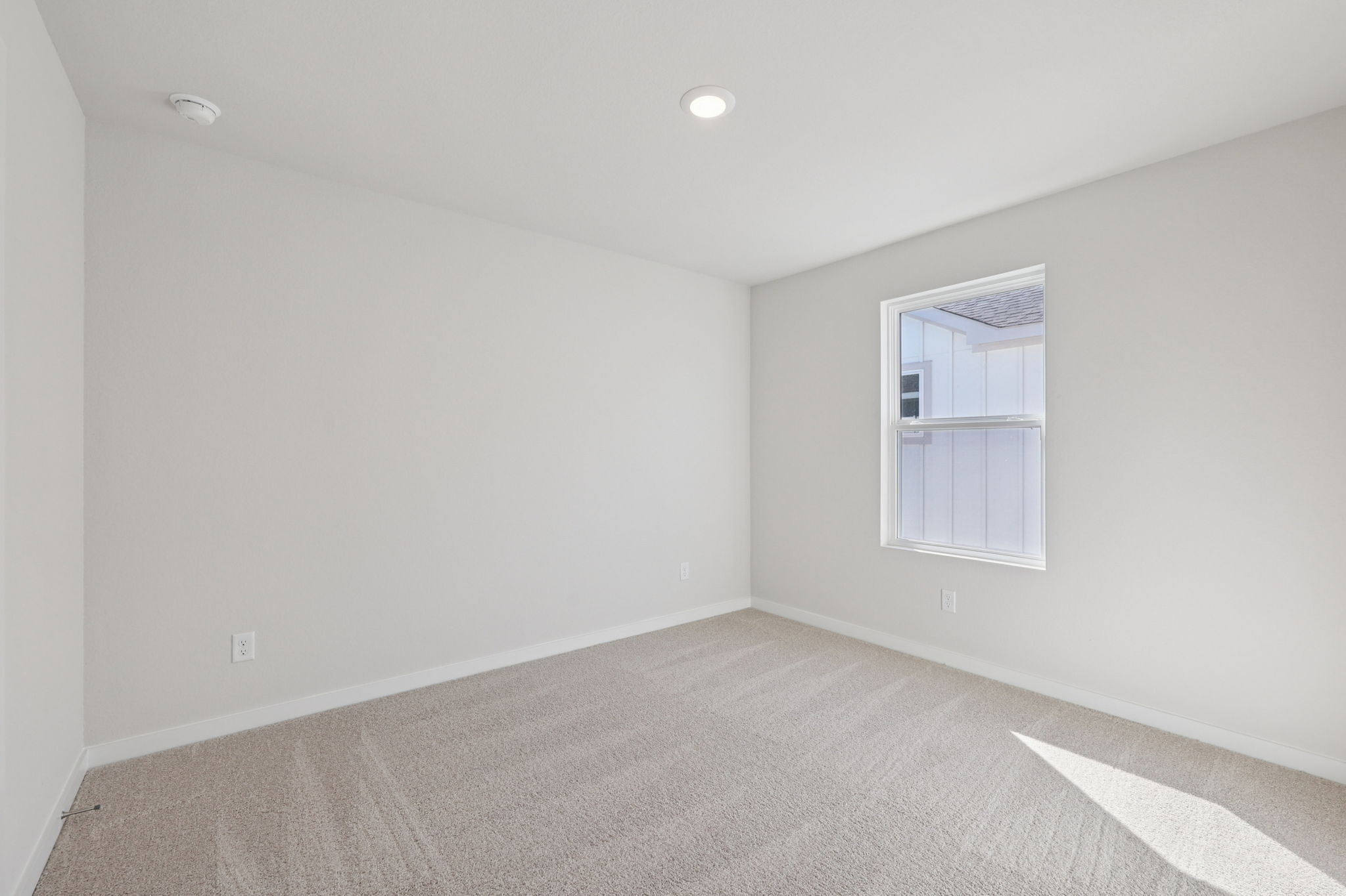 A room with a window and a carpet.