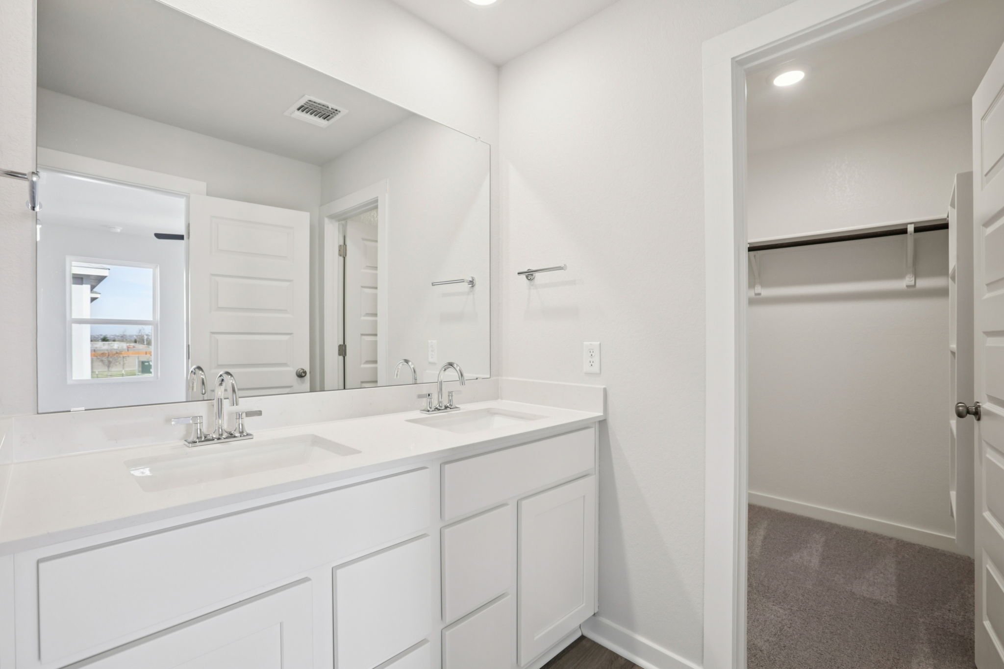 A bathroom with white cabinets.