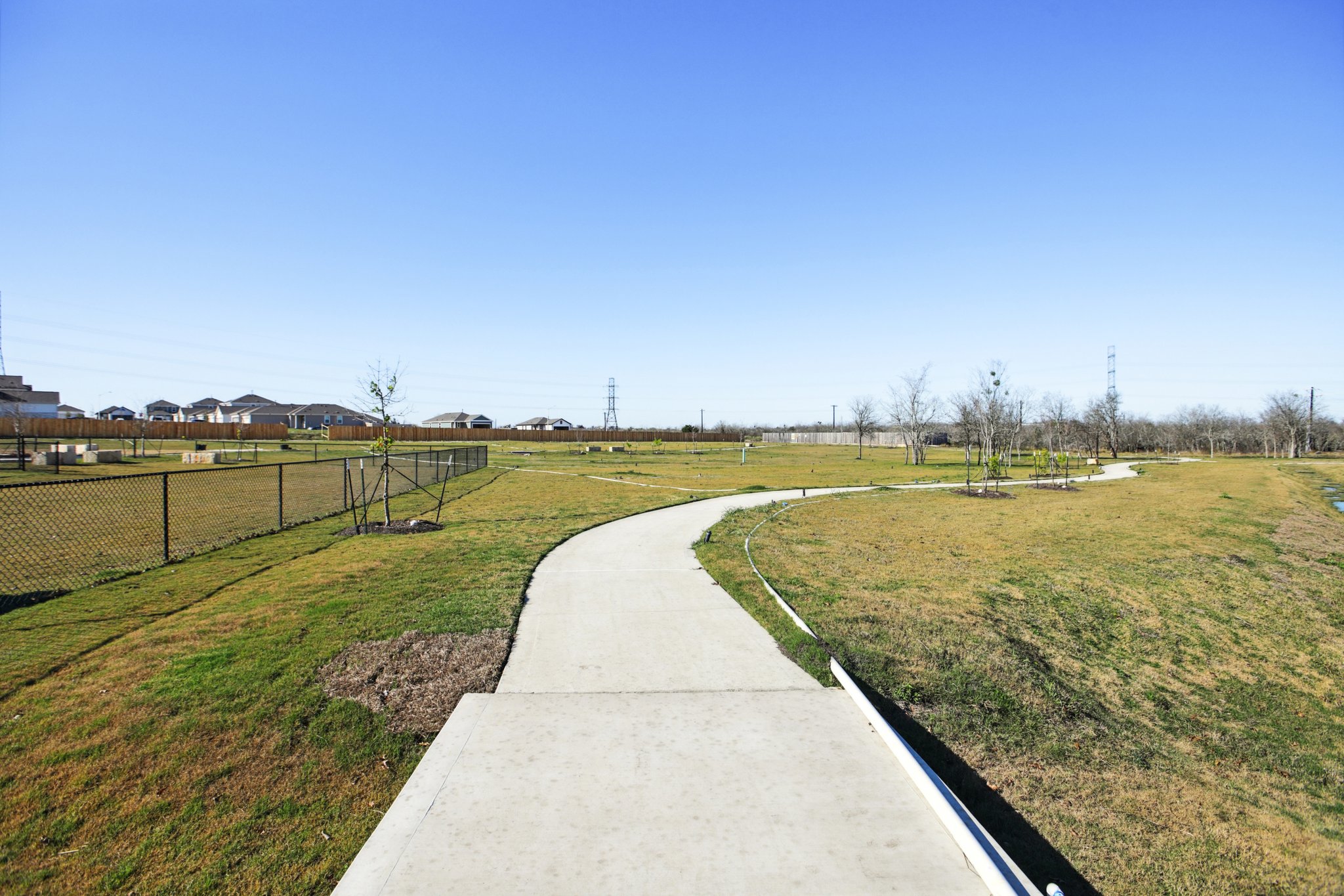 A concrete walkway with grass and trees.