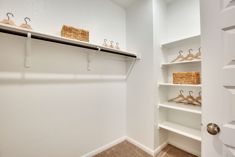 A white shelving unit with a basket and a basket on it.