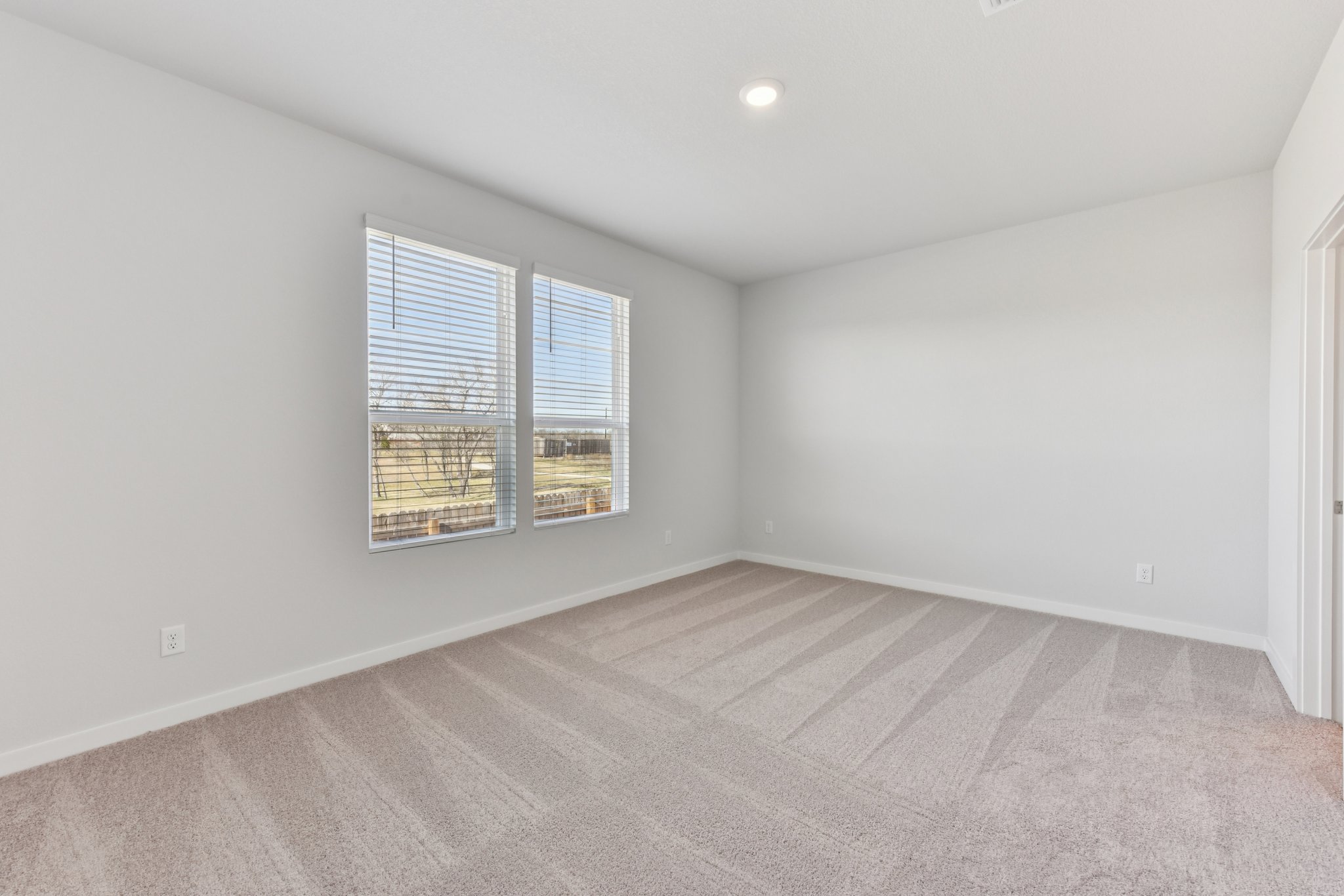 A room with a window and a carpet.