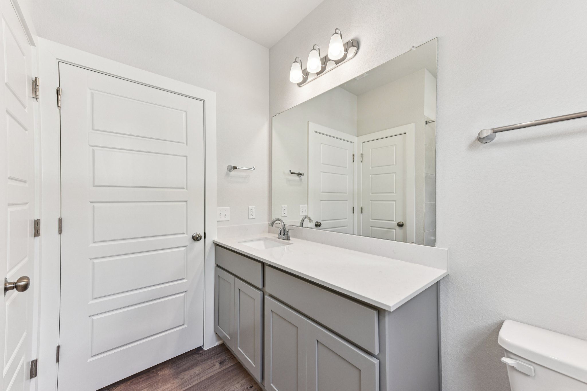A bathroom with white cabinets.