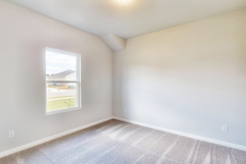 A room with a window and a carpet.