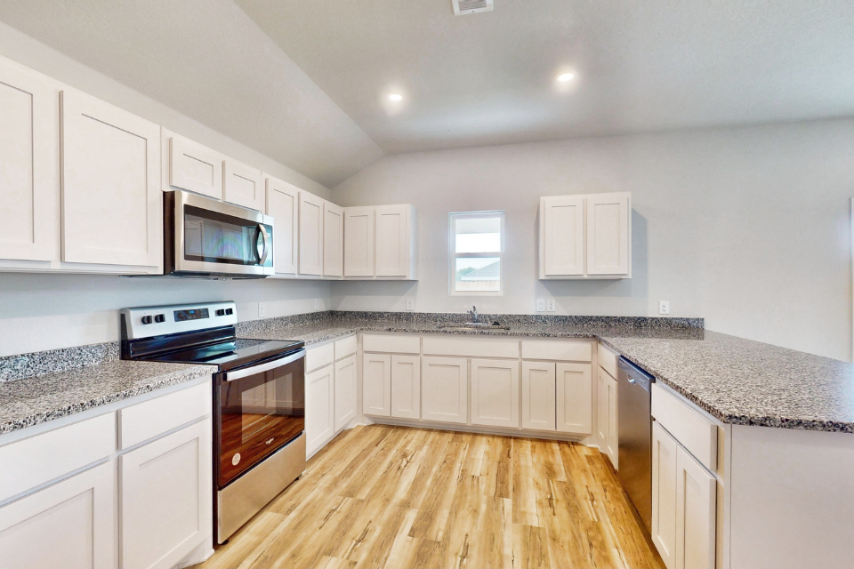 A kitchen with white cabinets.
